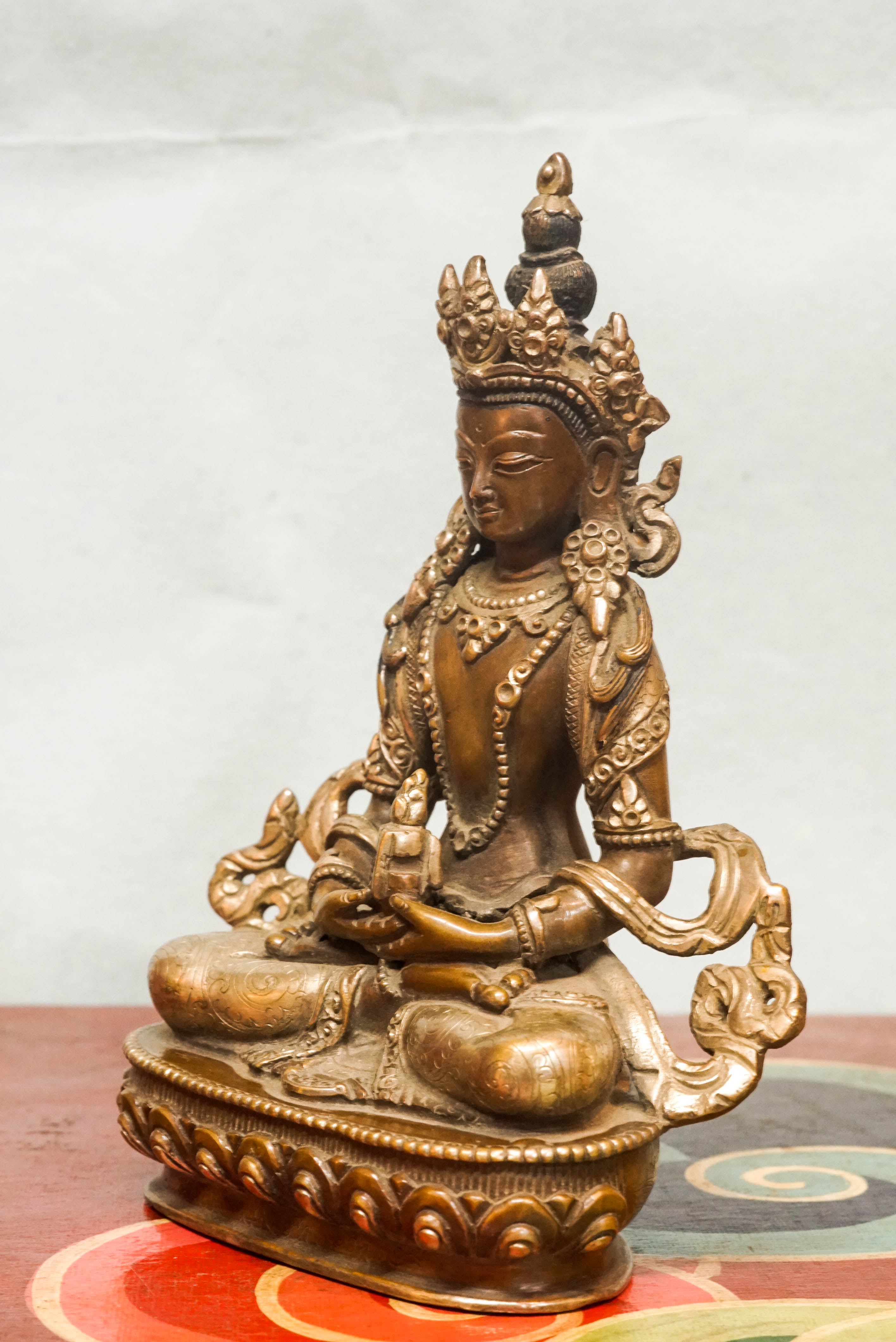 Seated Amitayus statue in lotus posture, symbolizing longevity, vitality, and spiritual wisdom.