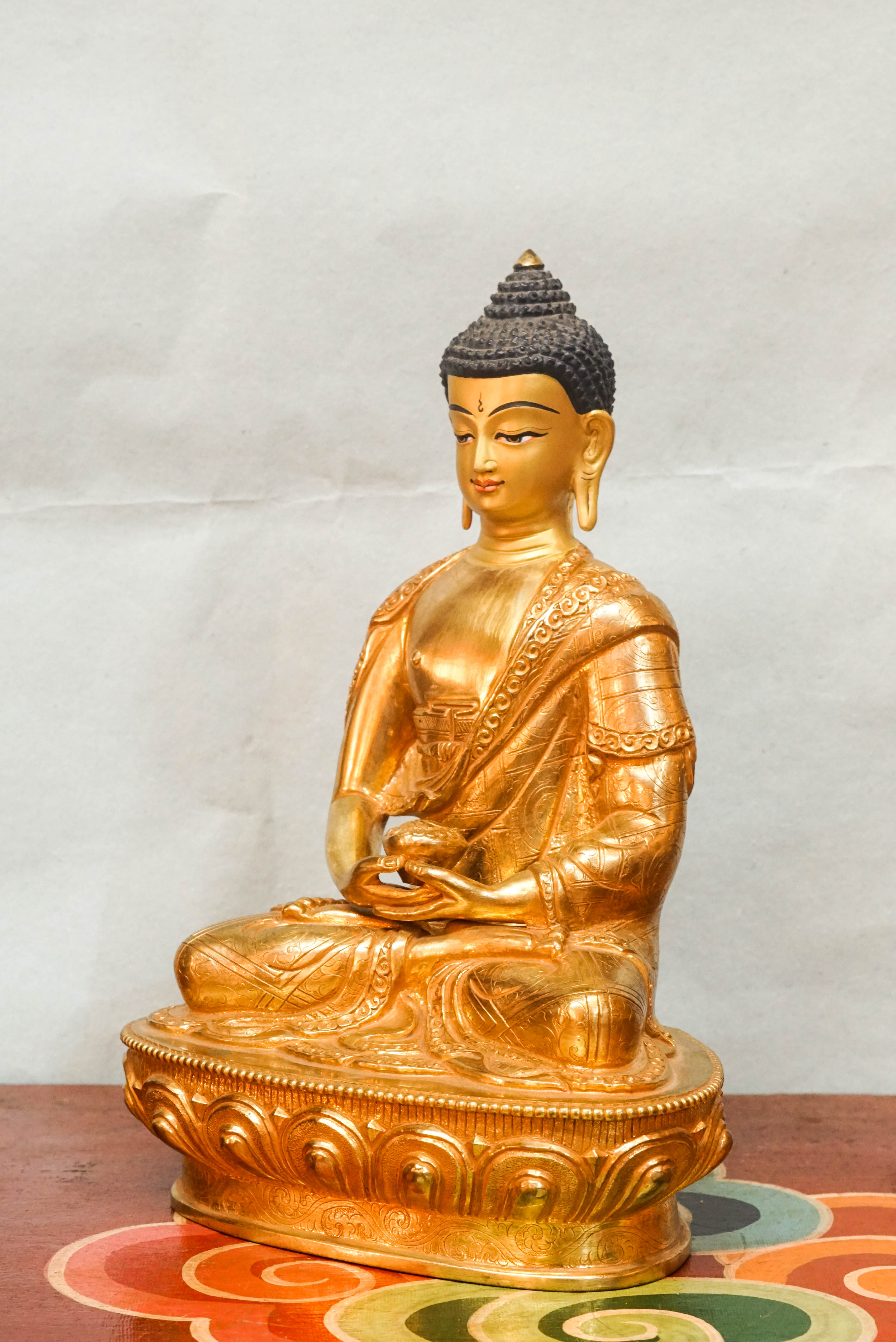 Gold Buddha statue with detailed robes and calm facial features, symbolizing spiritual awakening and inner harmony.
