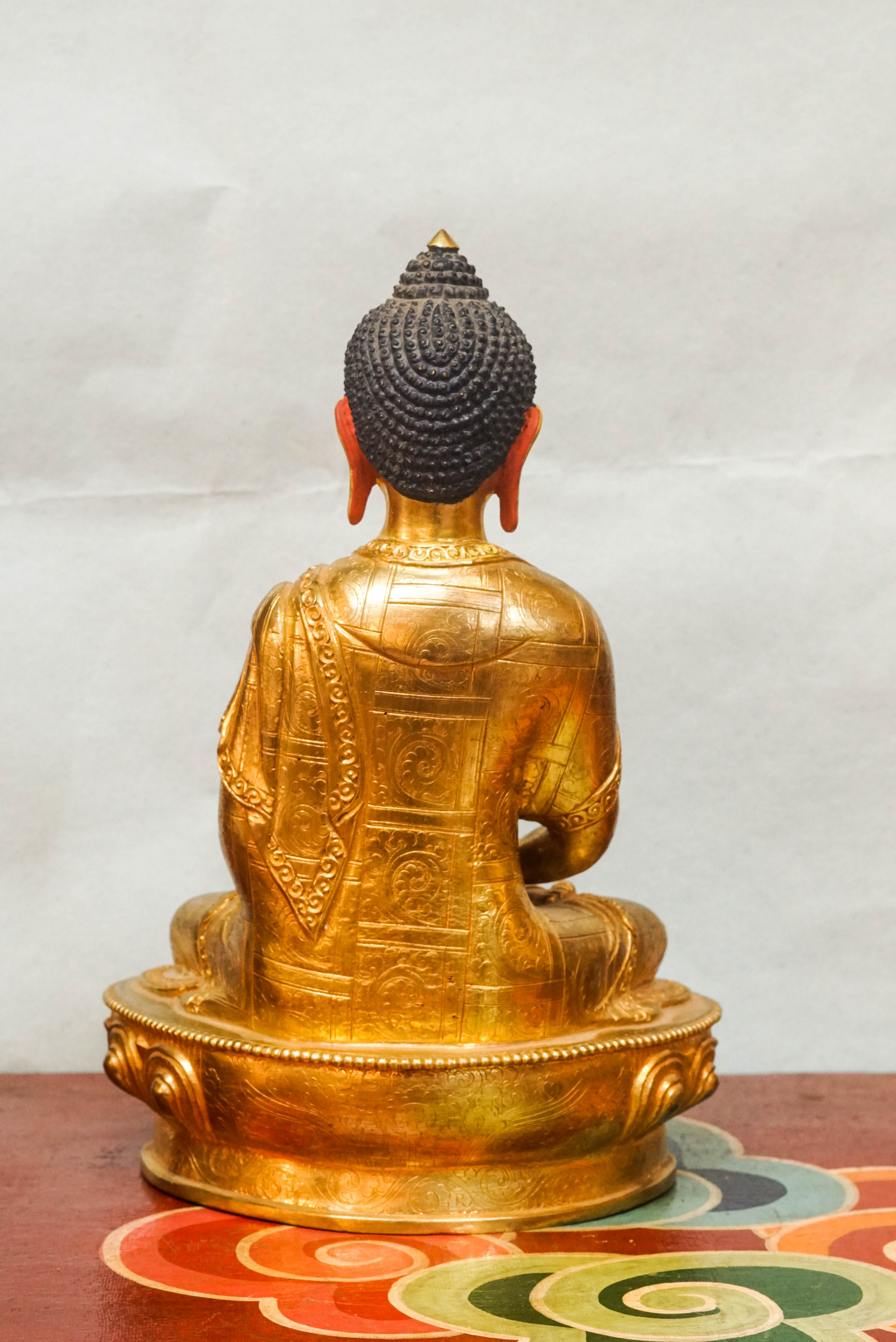 Gold Buddha statue with detailed robes and calm facial features, symbolizing spiritual awakening and inner harmony.