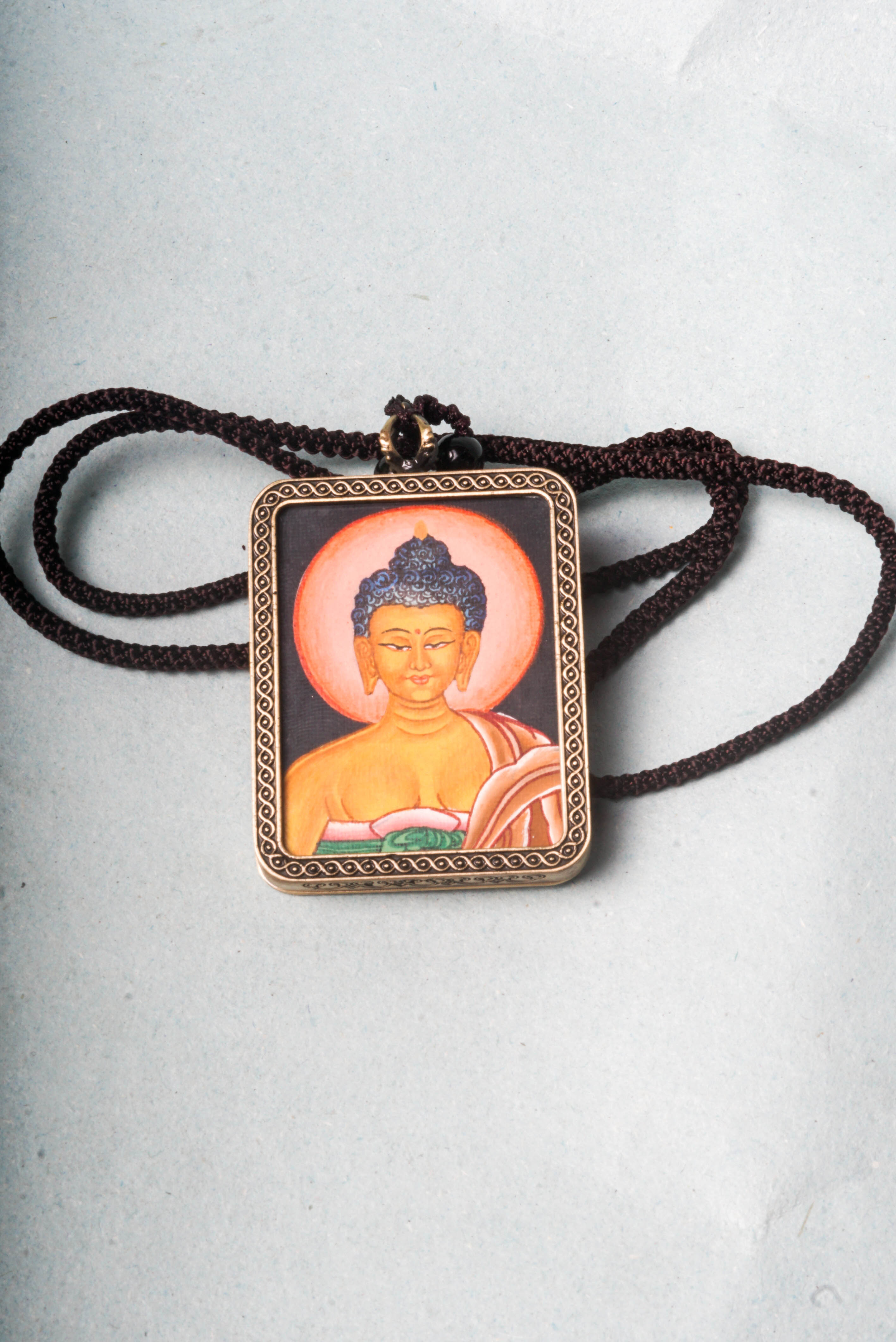 This Buddha Ghau Thangka captures the serene wisdom and compassion of the Buddha in a detailed, hand-painted portrait using natural mineral pigments. Designed as a portable shrine, it offers spiritual support whether carried or displayed, inspiring inner peace and mindfulness in daily practice.