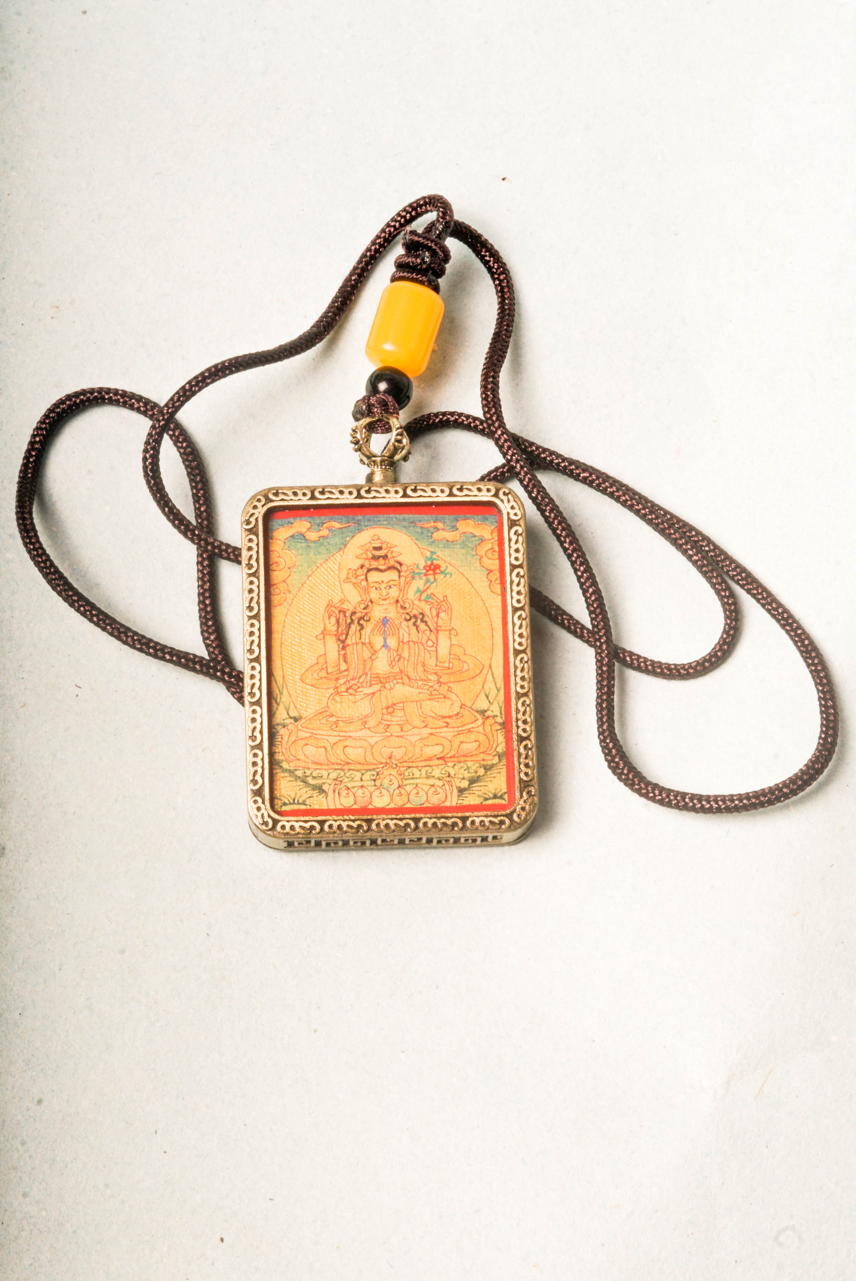 Chenrezig, the Bodhisattva of compassion, is depicted in this stunning gold Lyap Ghau Thangka, handcrafted by skilled artisans using natural mineral pigments. Perfect as a personal amulet or sacred display, it inspires meditation, protection, and spiritual growth.