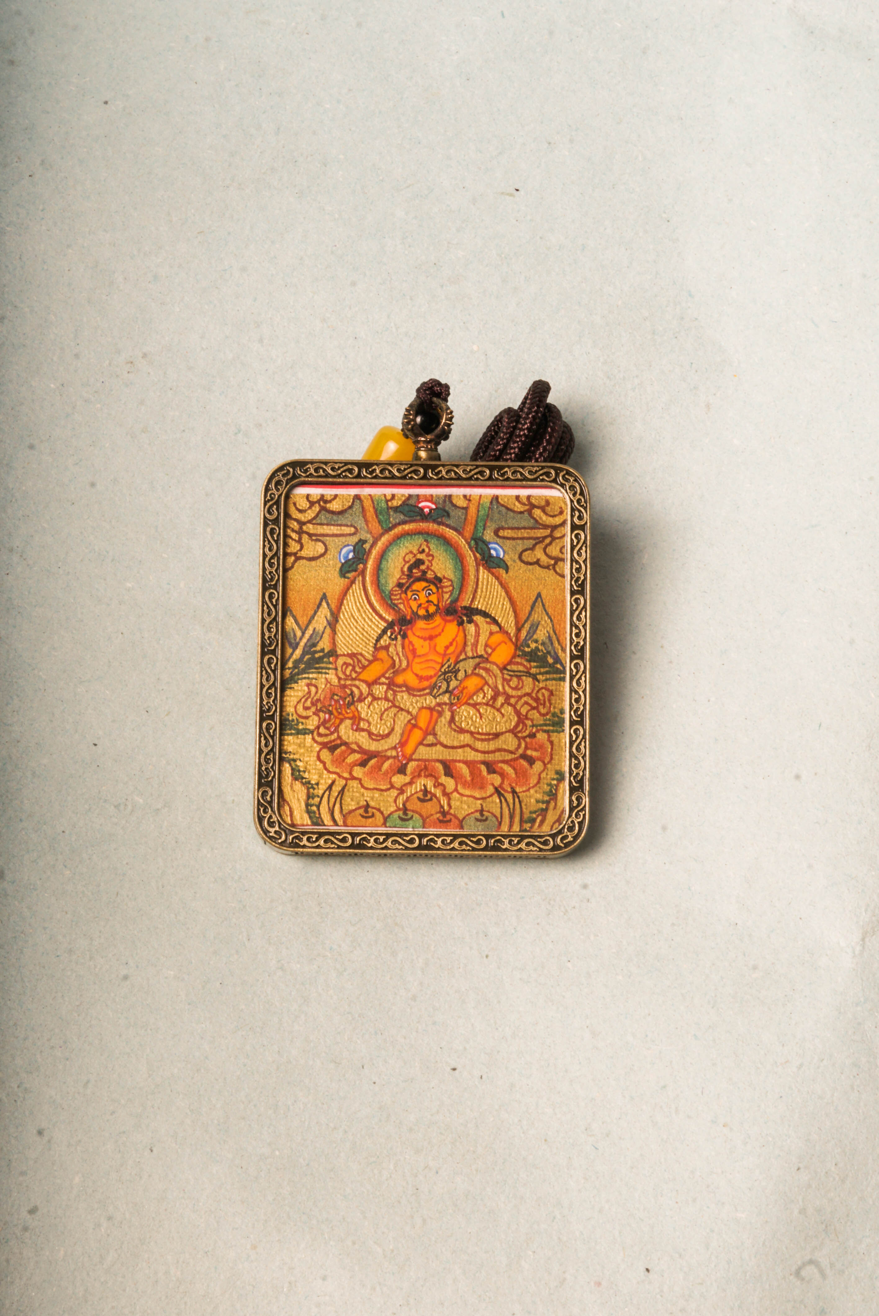 Zambala, the Tibetan Buddhist deity of wealth and prosperity, is revered for attracting abundance and removing obstacles. This Gold Zambala Thangka, hand-painted with mineral pigments and gold accents, embodies his blessings and brings spiritual harmony and success to your space.