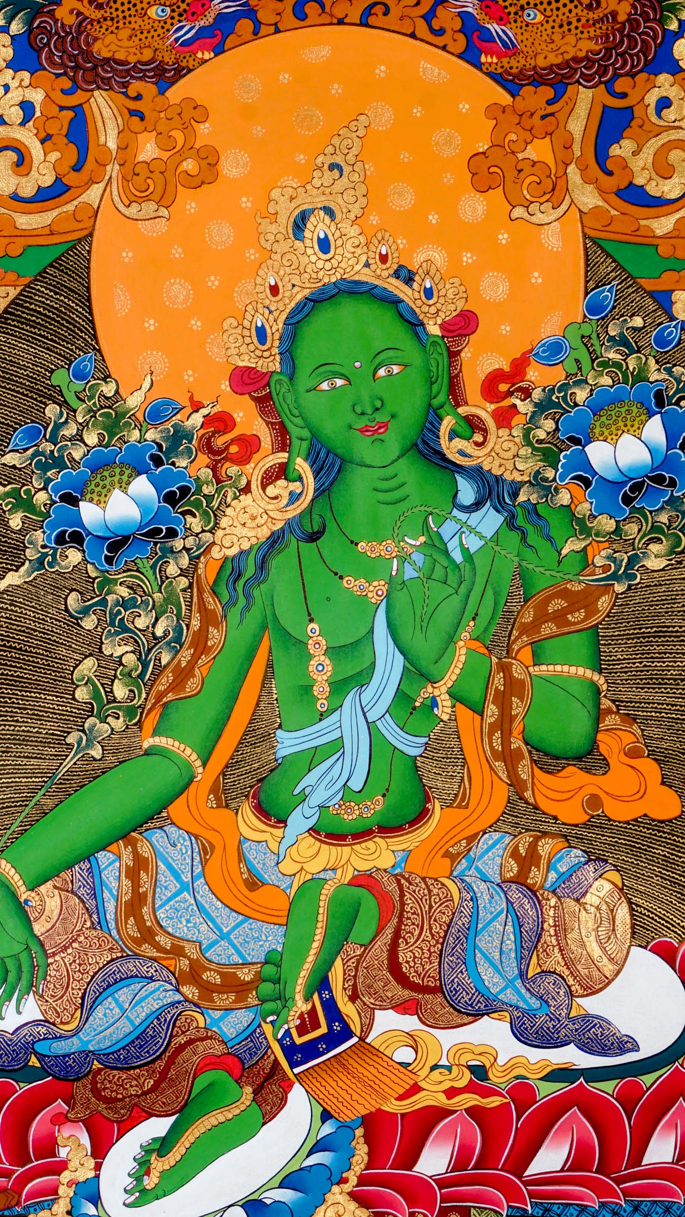 Tibetan thangka of Green Tara in green form seated in lalitasana on a golden lotus throne, right hand in varada mudra, left hand holding a blue lotus, surrounded by flowers and divine light.