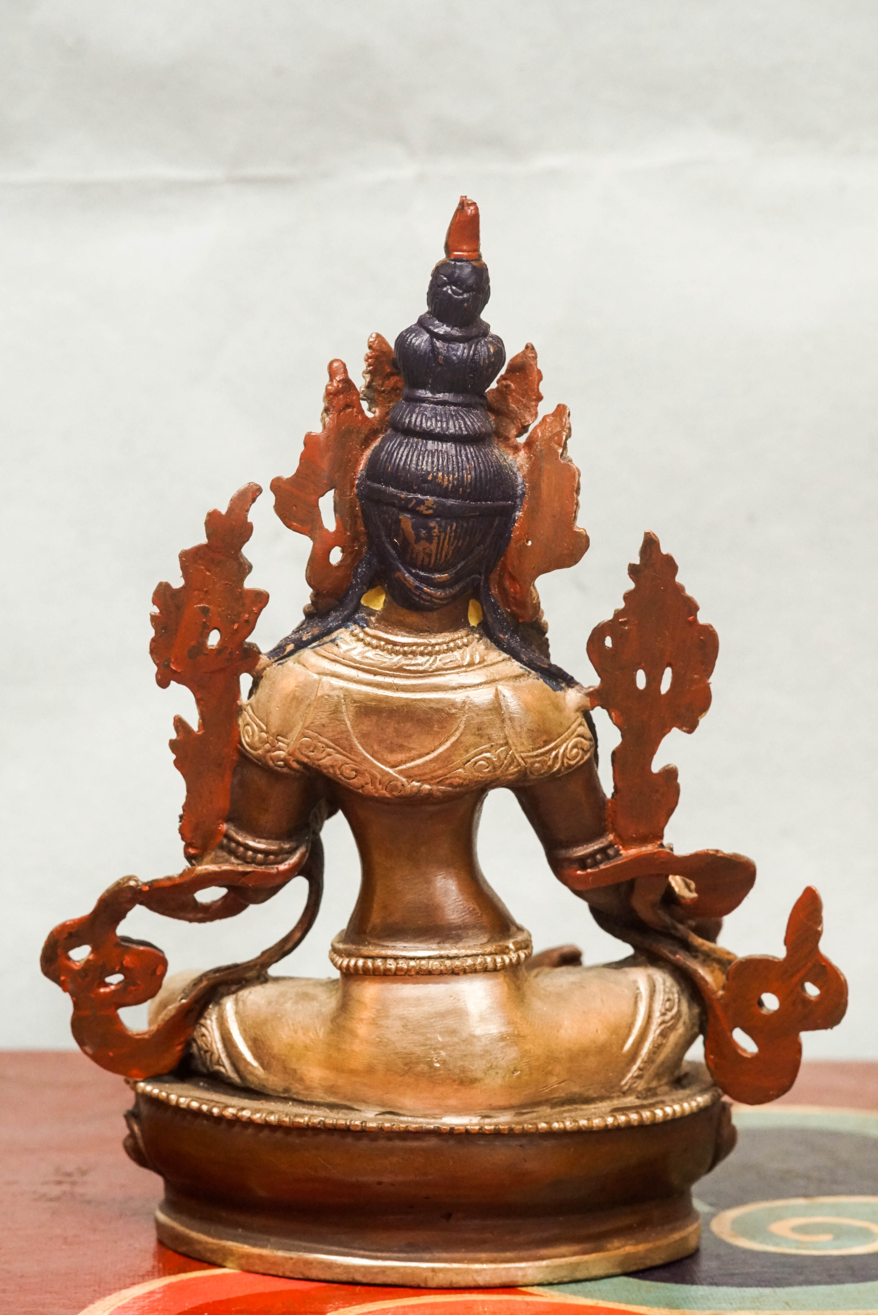 Statue of Green Tara, the female Bodhisattva of compassion and protection, seated with one leg extended, symbolizing her readiness to respond to suffering.