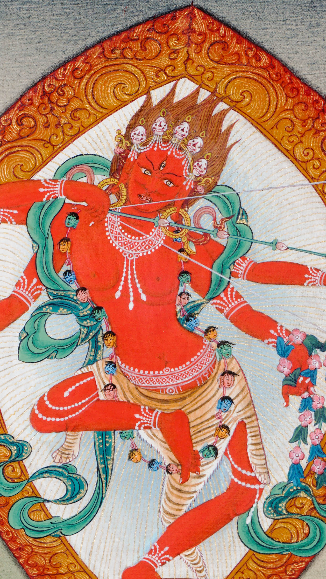 Tibetan thangka painting of red goddess Kurukulla dancing in archer’s pose, holding a flower bow and arrow, surrounded by a golden halo, symbolizing magnetizing energy and compassion.
