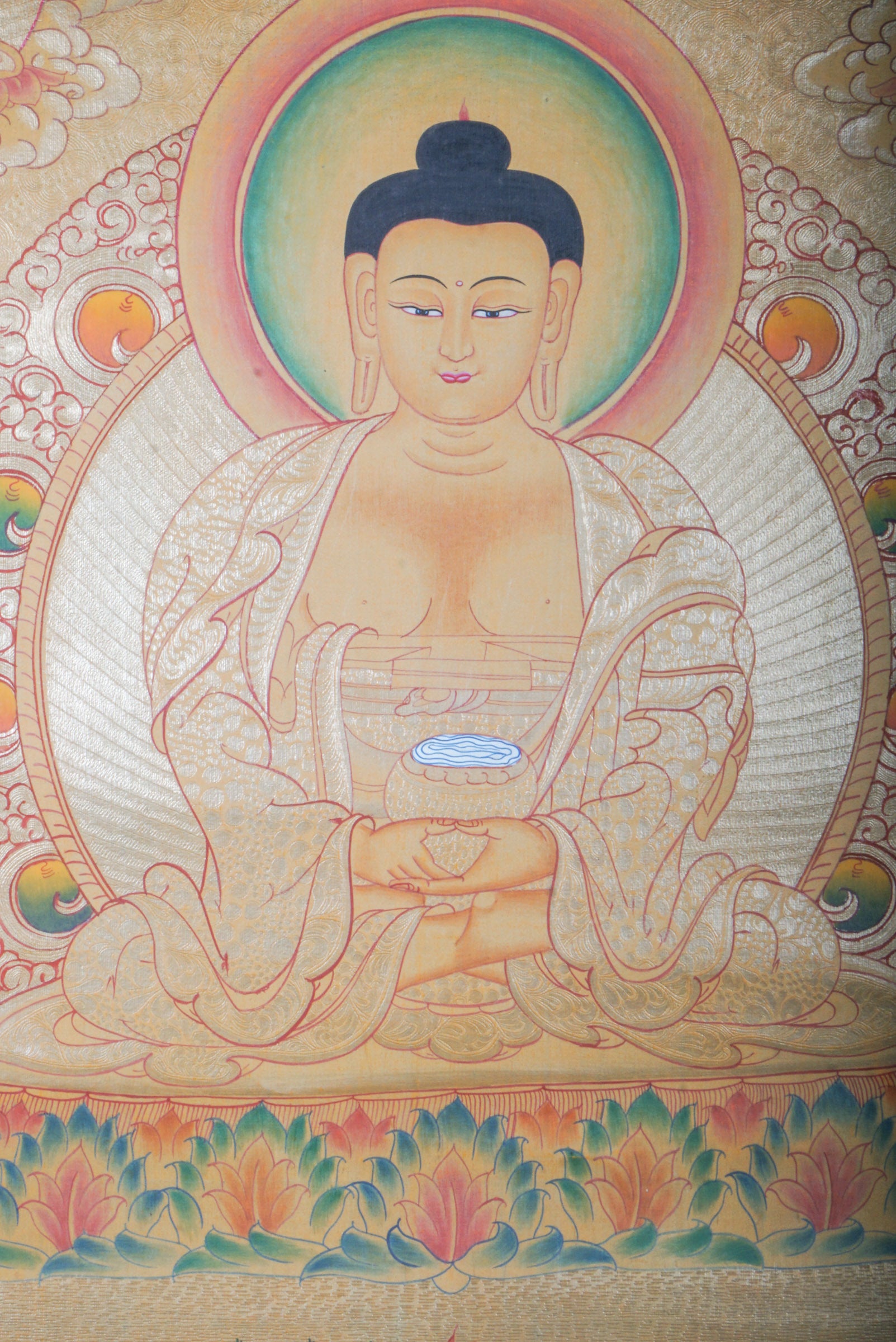 Amitabha Buddha on Gold- a depiction of a seated Buddha figure with decorative elements on a textured background