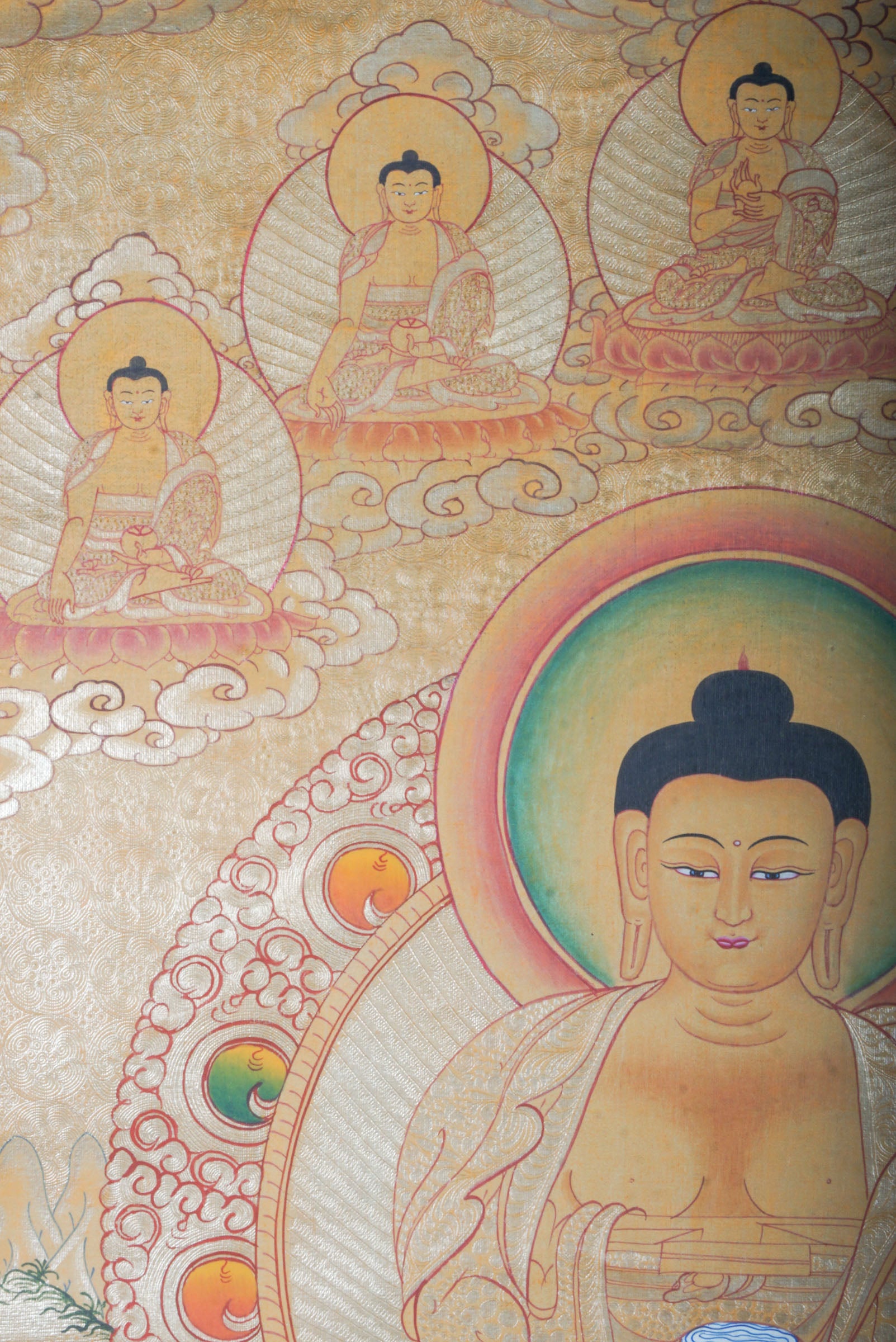 Amitabha Buddha on Gold- a depiction of a seated Buddha figure with decorative elements on a textured background