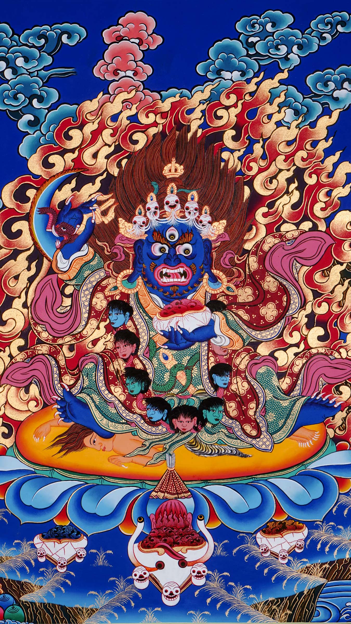 Hand-painted Mahākāla thangka from Kathmandu, Nepal depicting the wrathful protector deity with dark blue body, skull crown of five skulls, garland of severed heads, holding skull cup and curved knife, surrounded by red flames in traditional Tibetan Vajrayana style.