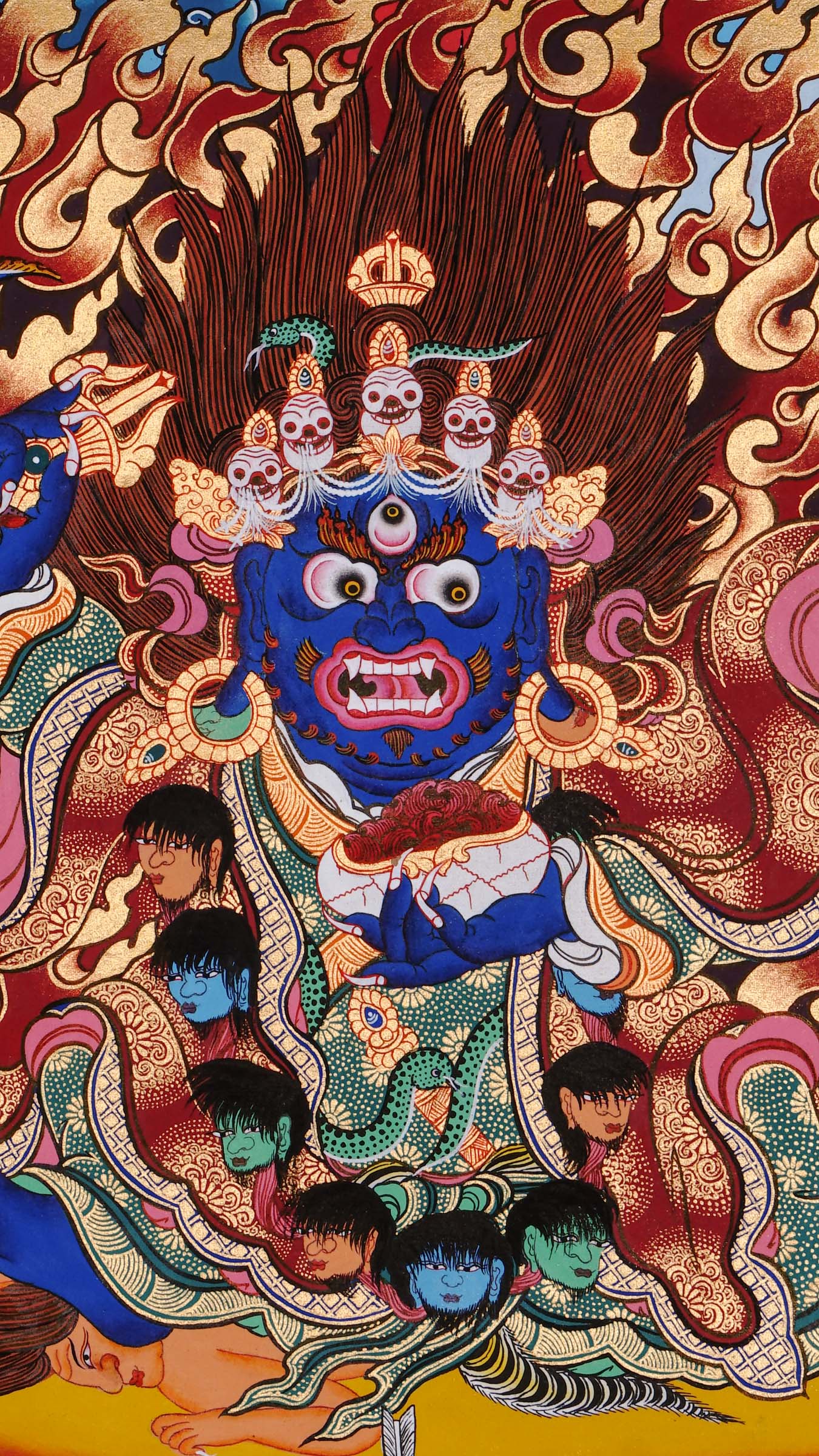 Hand-painted Mahākāla thangka from Kathmandu, Nepal depicting the wrathful protector deity with dark blue body, skull crown of five skulls, garland of severed heads, holding skull cup and curved knife, surrounded by red flames in traditional Tibetan Vajrayana style.
