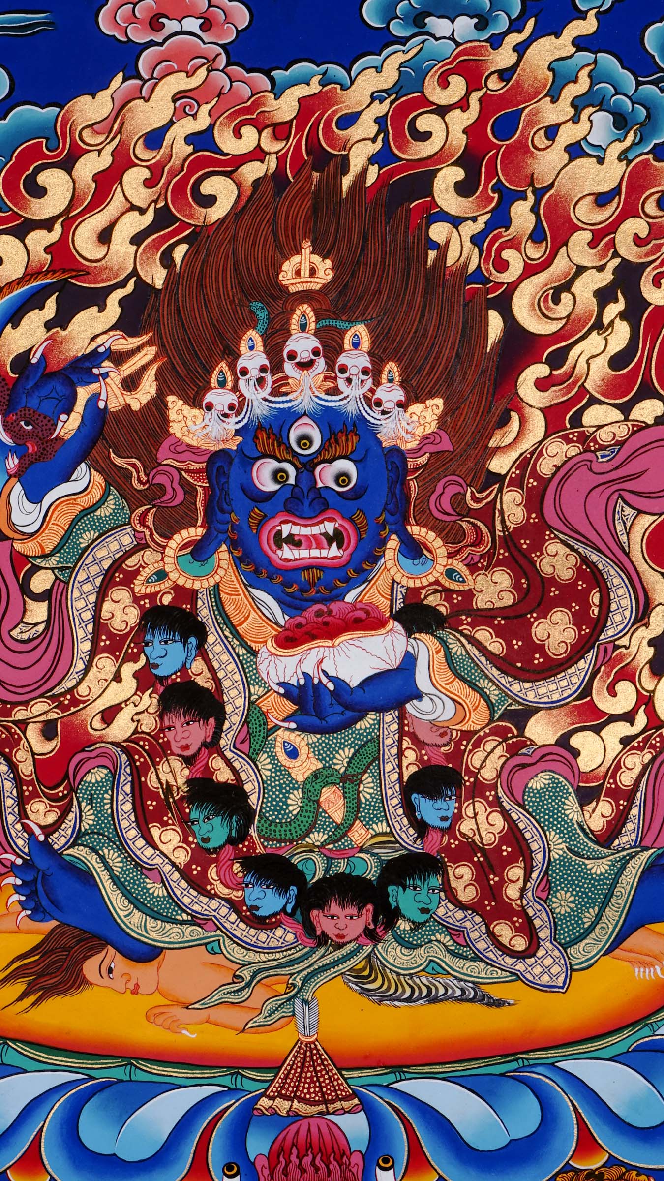 Hand-painted Mahakala thangka from Kathmandu, Nepal depicting the wrathful protector deity with dark blue body, skull crown of five skulls, garland of severed heads, holding skull cup and curved knife, surrounded by red flames in traditional Tibetan Vajrayana style.