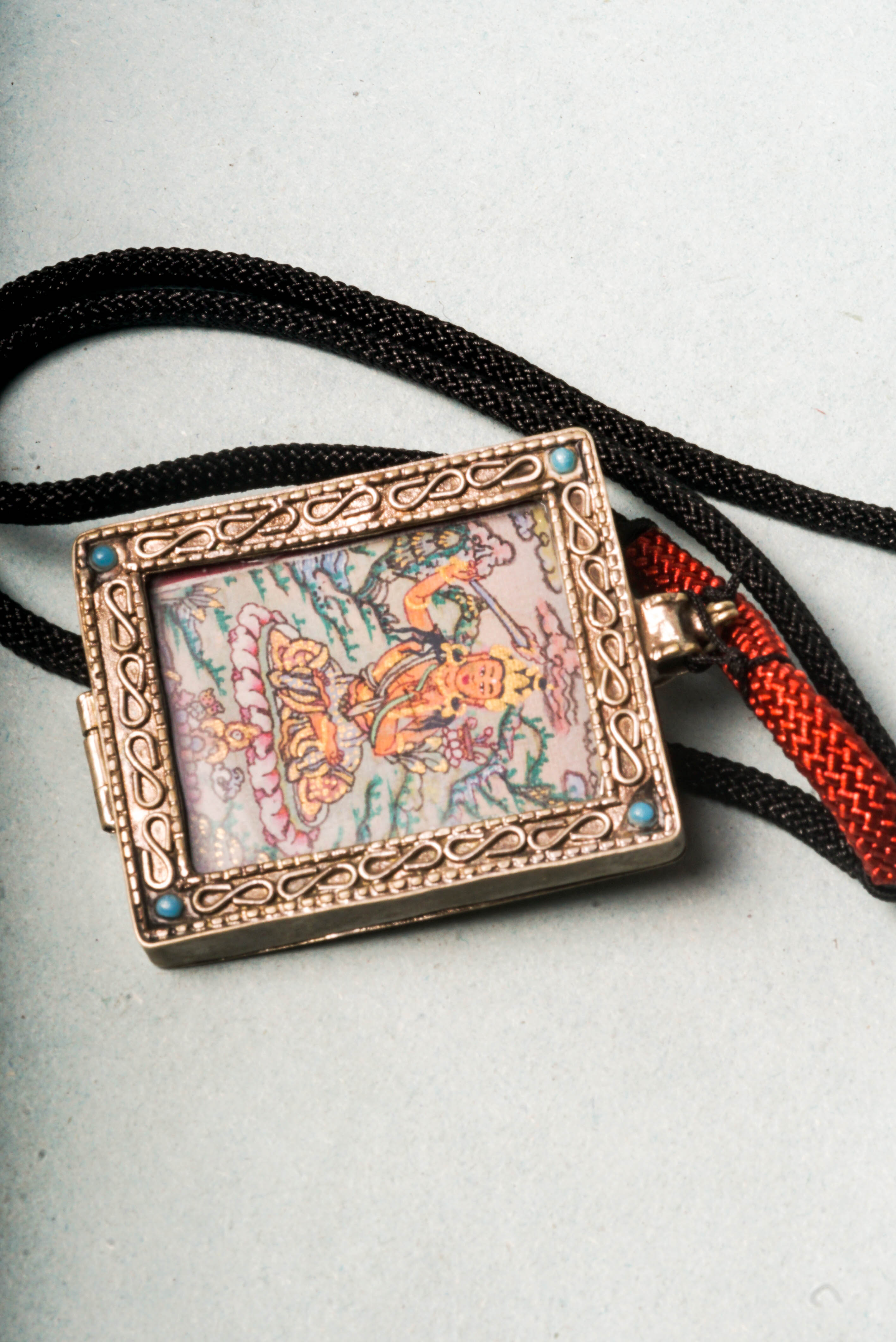 The Manjushri Ghau Thangka depicts the Bodhisattva of Wisdom, symbolizing clarity and insight. Hand-painted in a portable shrine format, it features his iconic sword and scripture, aiding in meditation and the pursuit of spiritual knowledge.