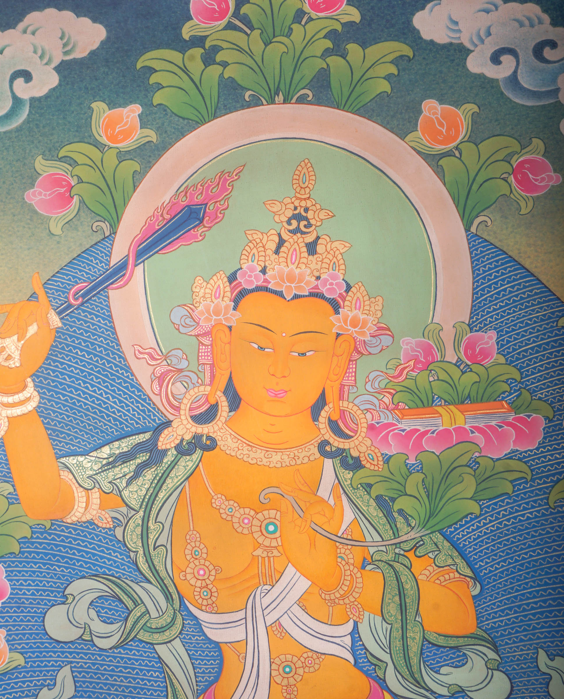 This genuine Tibetan Thangka of Manjushri features the Bodhisattva of wisdom holding a sword and scripture, symbolizing the cutting of ignorance and mastery of Buddhist teachings. Hand-painted with natural mineral pigments, this Buddhist artwork embodies clarity, insight, and spiritual guidance.