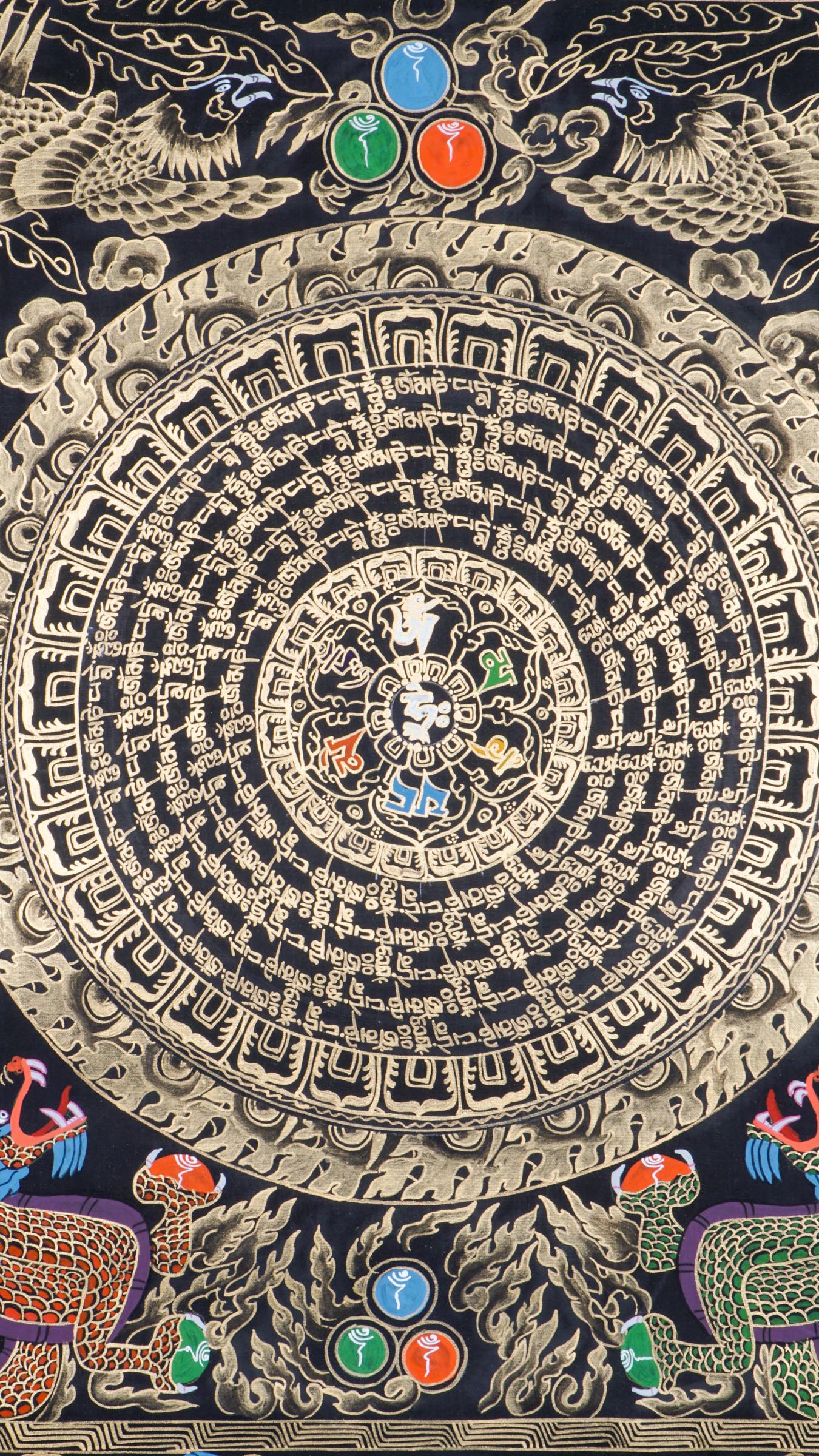Tibetan mantra mandala thangka with concentric rings of sacred script surrounding a central symbol, framed by dragons and ornate gold detailing on a black background.