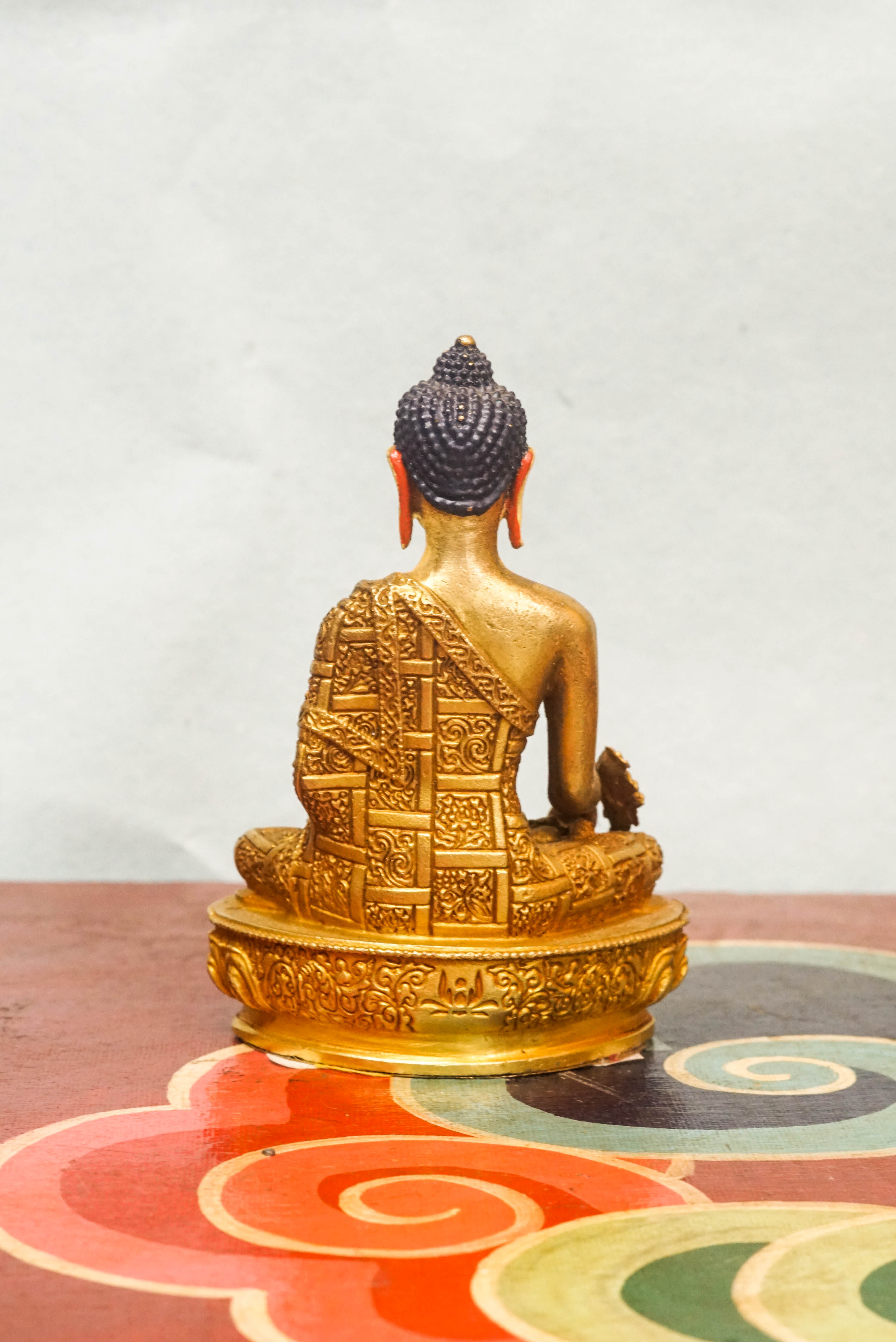 Handcrafted Medicine Buddha statue with fully opened eyes, holding a healing bowl, surrounded by a radiant lapis aura, seated on a lotus pedestal.