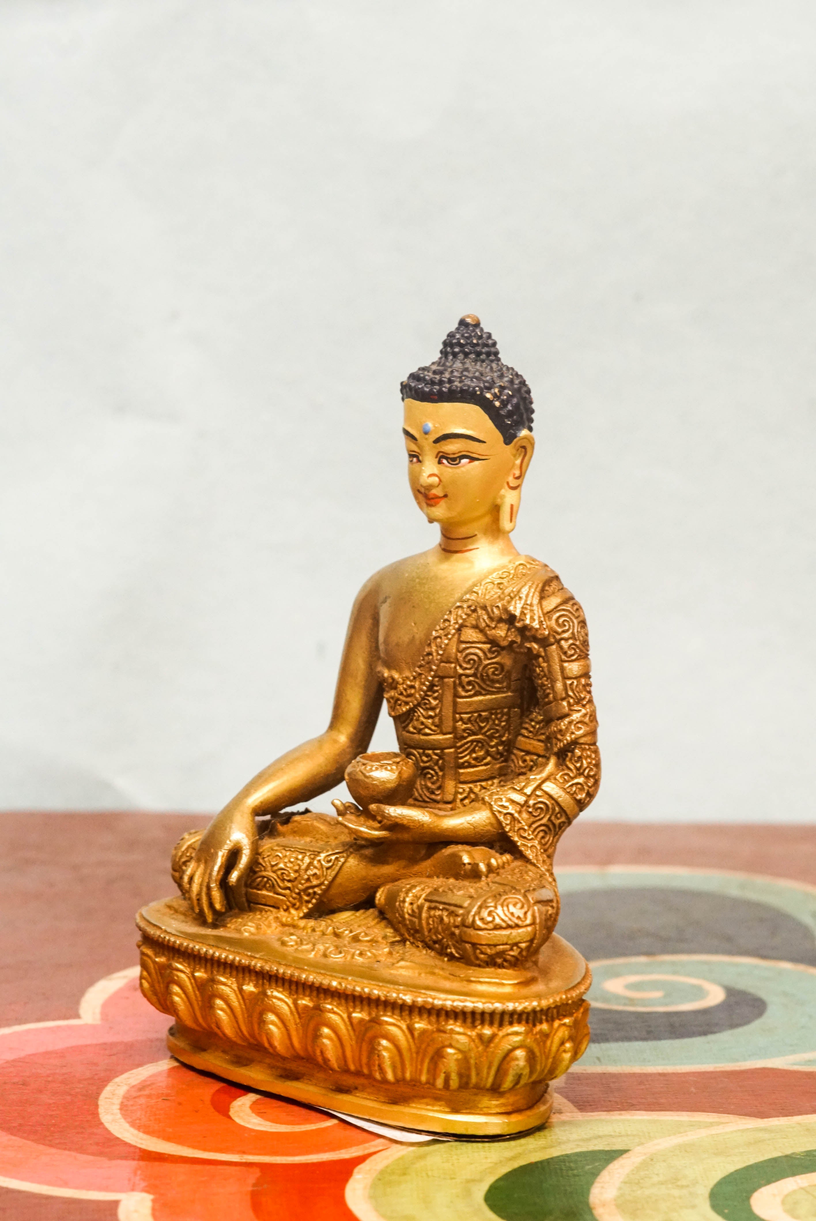 Handcrafted Shākyamuni Buddha statue seated in lotus posture with a radiant golden aura, symbolizing enlightenment, clarity, and spiritual presence.