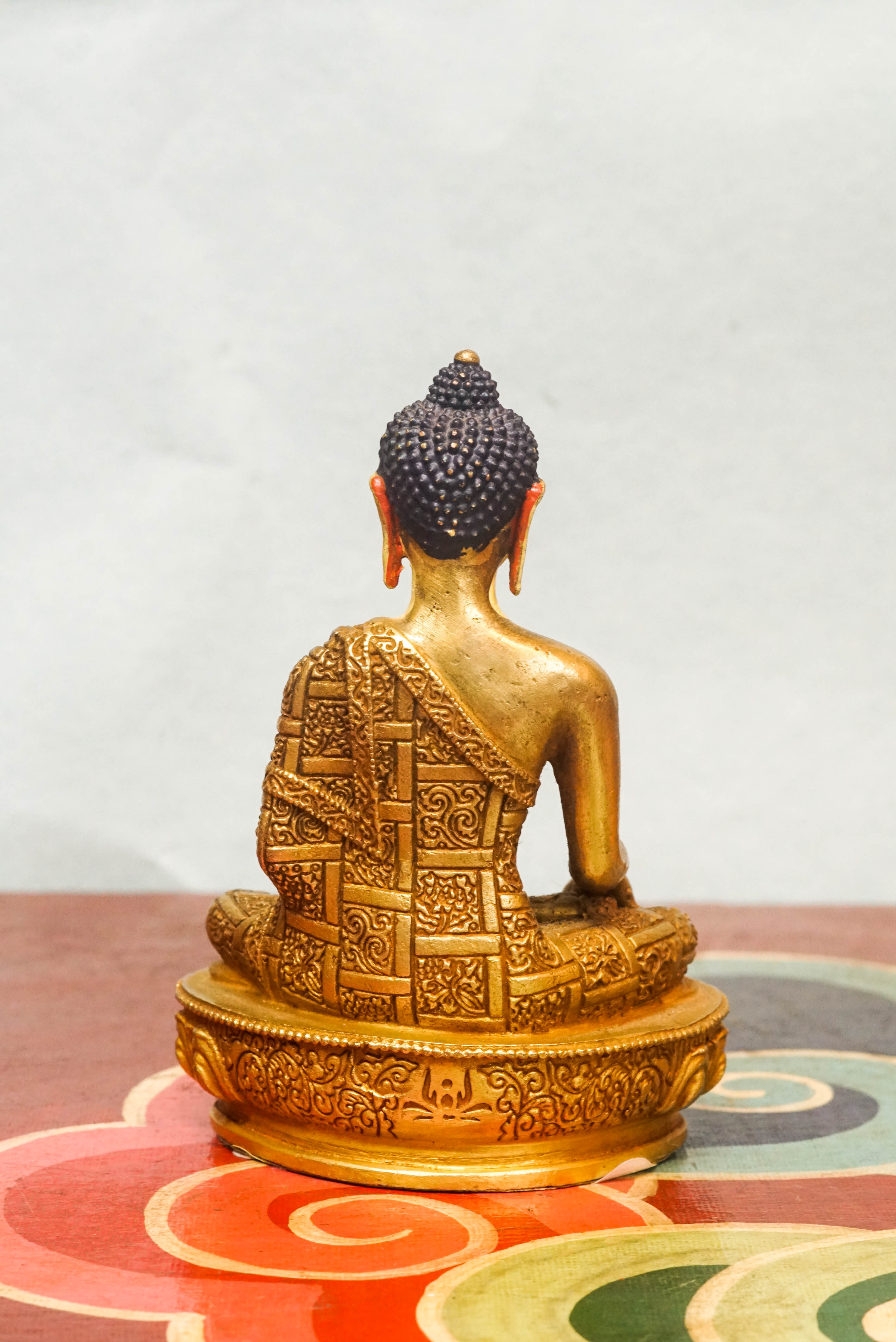 Handcrafted Shākyamuni Buddha statue seated in lotus posture with a radiant golden aura, symbolizing enlightenment, clarity, and spiritual presence.