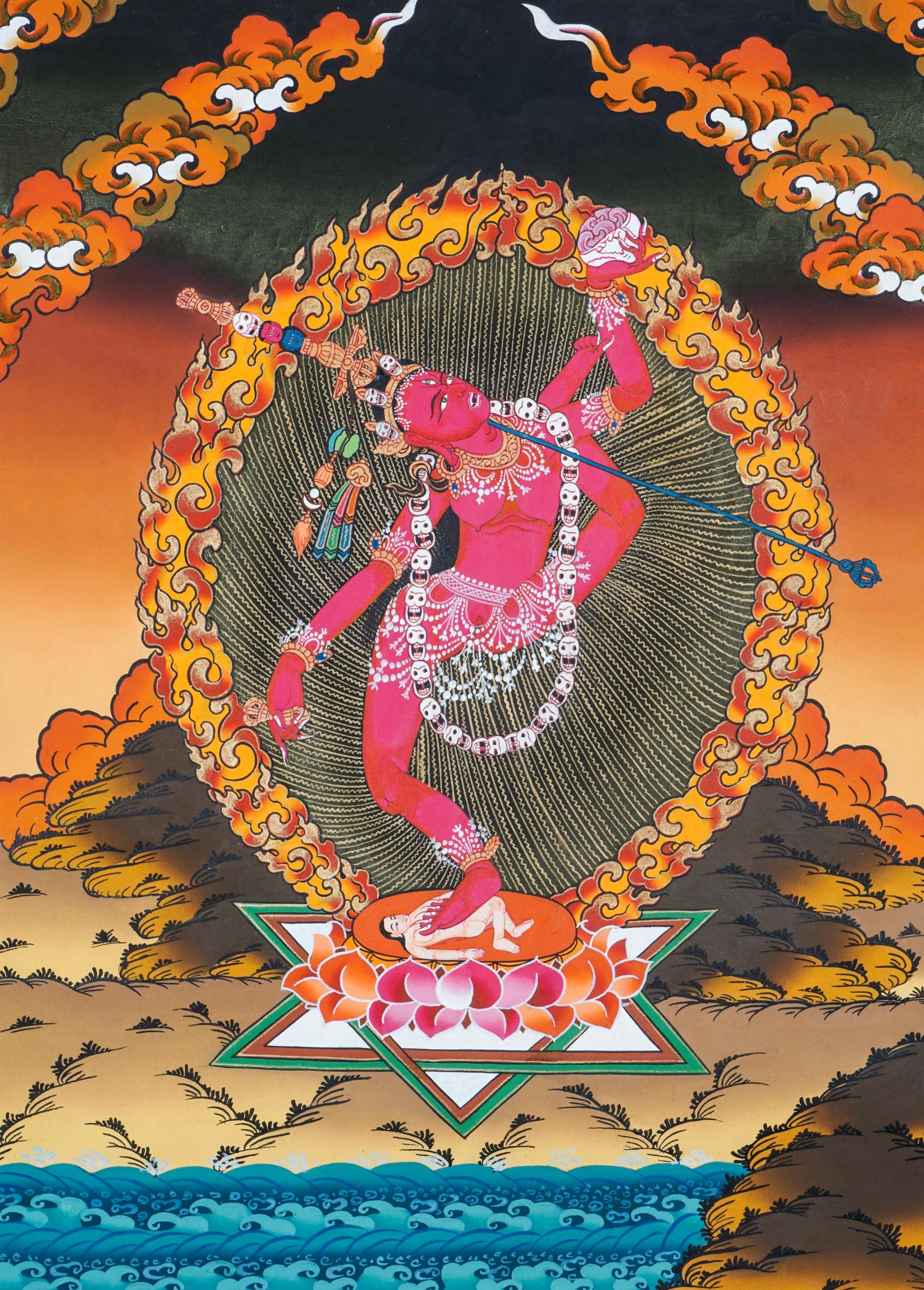 Traditional Tibetan thangka painting depicting Vajrayogini in a dynamic dancing pose on a lotus throne, encircled by flames and clouds, holding ritual implements against a warm, mountainous landscape.