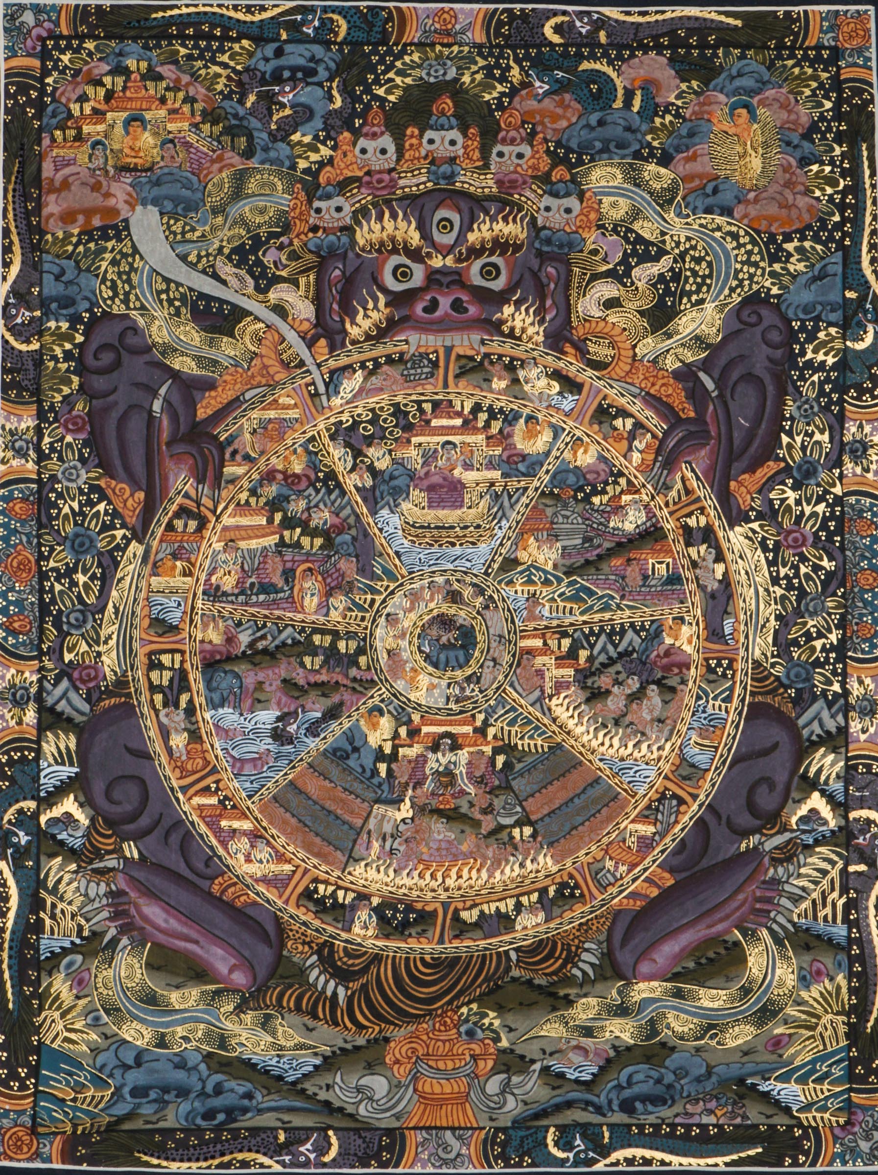 Detailed thangka-style painting showing a large circular wheel divided into multiple sections filled with small human figures, animals, buildings, and landscape scenes, surrounded by concentric decorative rings and held by a large blue multi-eyed figure with extended arms, set against a dark background with clouds, flames, and ornate gold, red, and blue patterns.