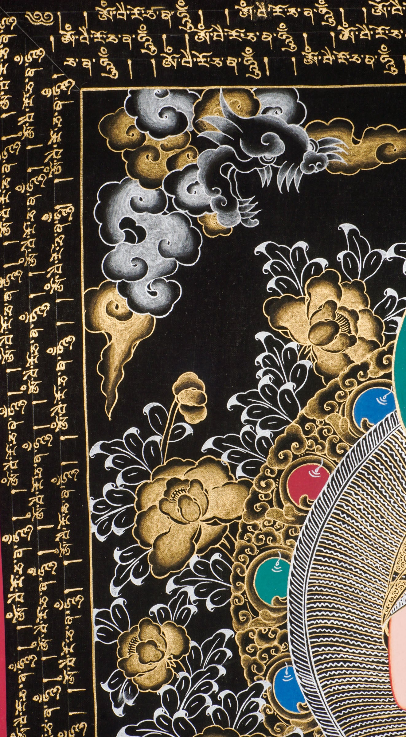 Traditional Tibetan thangka painting depicting White Buddha seated in meditation on a lotus throne, with hands in a teaching gesture, surrounded by intricate gold floral motifs on a black background and framed by sacred script.
