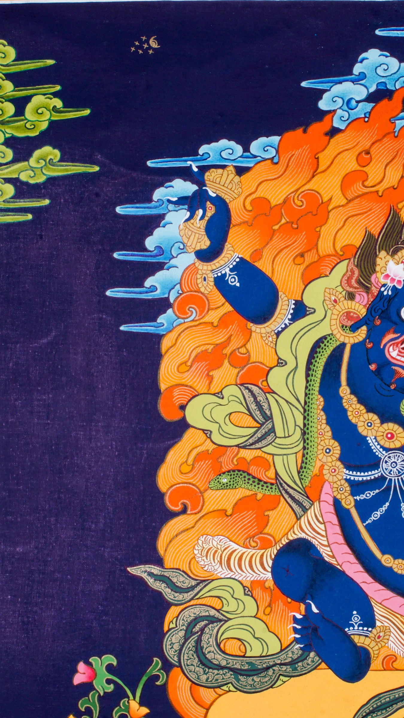 Traditional Tibetan thangka painting depicting wrathful Vajrapani, a blue-skinned deity in a powerful dynamic pose on a lotus throne, surrounded by blazing flames, clouds, and ornate symbolic details against a deep blue background.