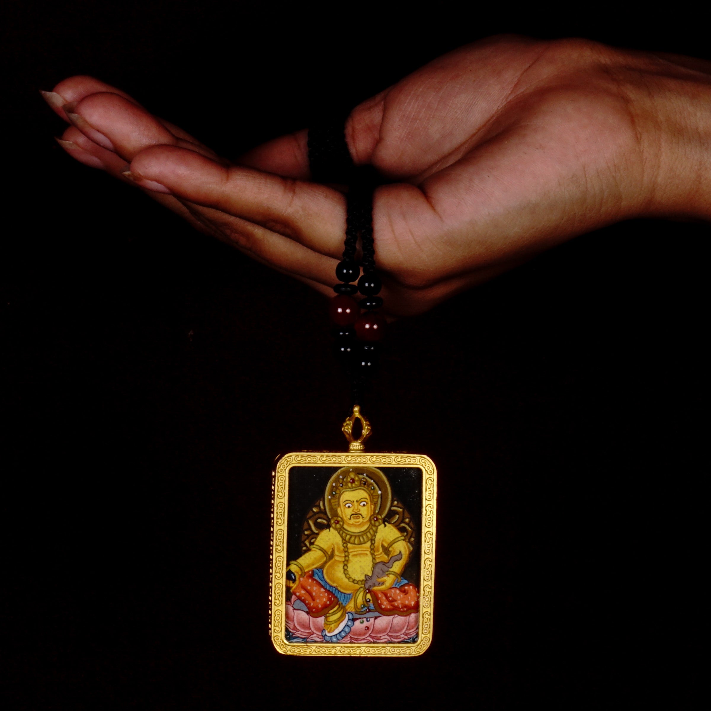 Hand-painted Yellow Zambala miniature Thangka pendant in gold-accented copper Ghau locket with black beaded cord.