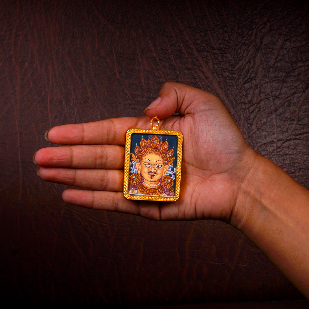 Yellow Zambhala Ghau pendant in a decorative gold-tone frame featuring a miniature Tibetan Buddhist wealth deity artwork handcrafted in Nepal.