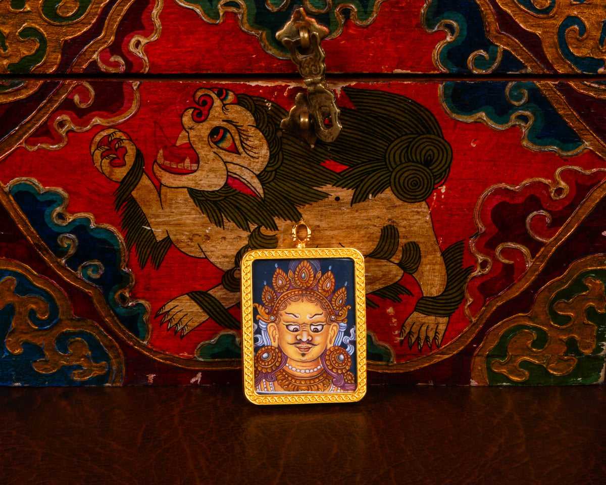 Yellow Zambhala Ghau pendant in a decorative gold-tone frame featuring a miniature Tibetan Buddhist wealth deity artwork handcrafted in Nepal.