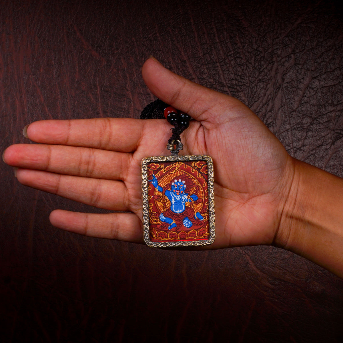 Khadgapani (Black Manjushree) Ghau pendant featuring a miniature Tibetan Buddhist wisdom protector artwork in a traditional metal frame handcrafted in Nepal.