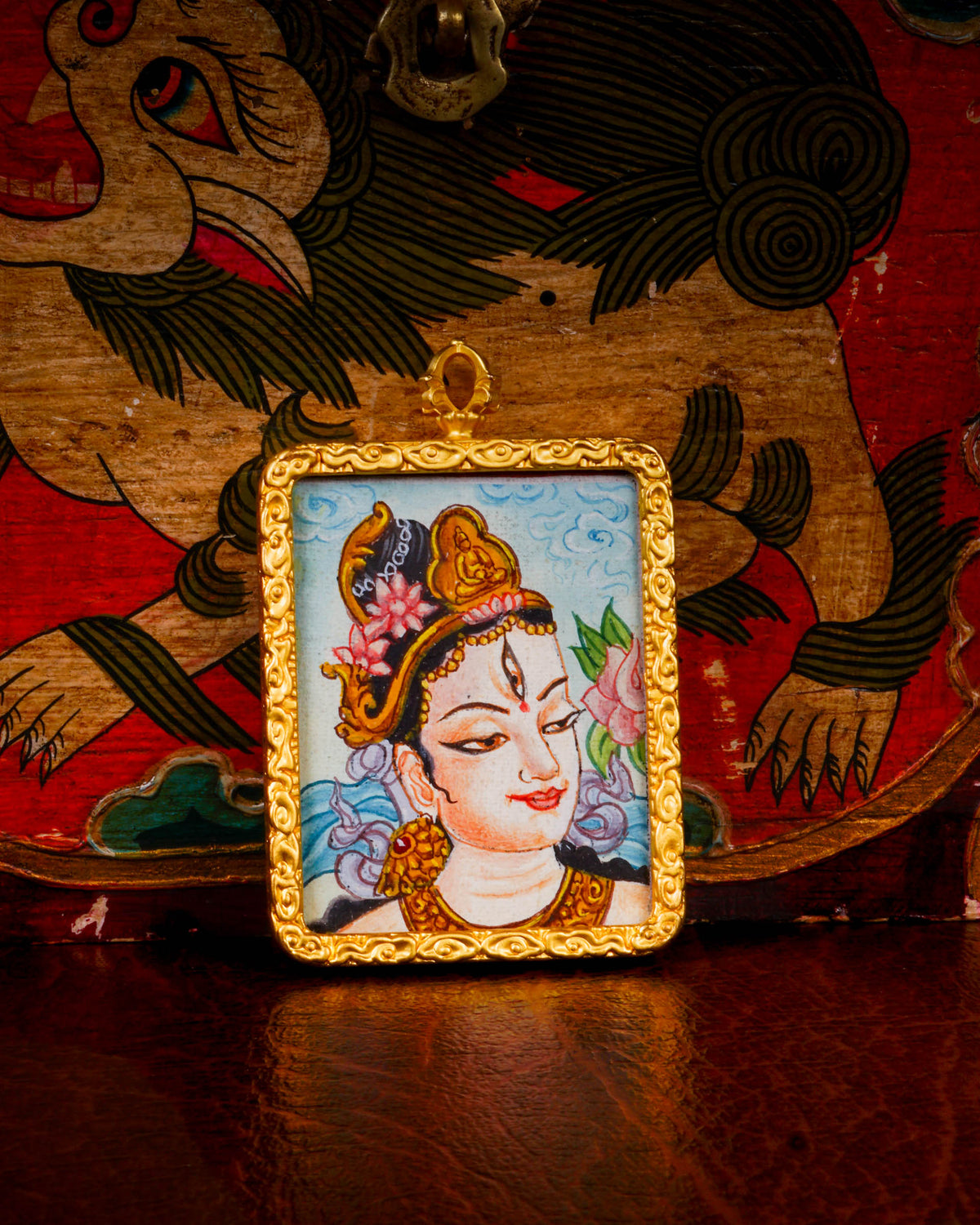 White Tara Ghau pendant featuring a miniature Tibetan Buddhist goddess of compassion artwork in a decorative gold-tone frame handcrafted in Nepal.