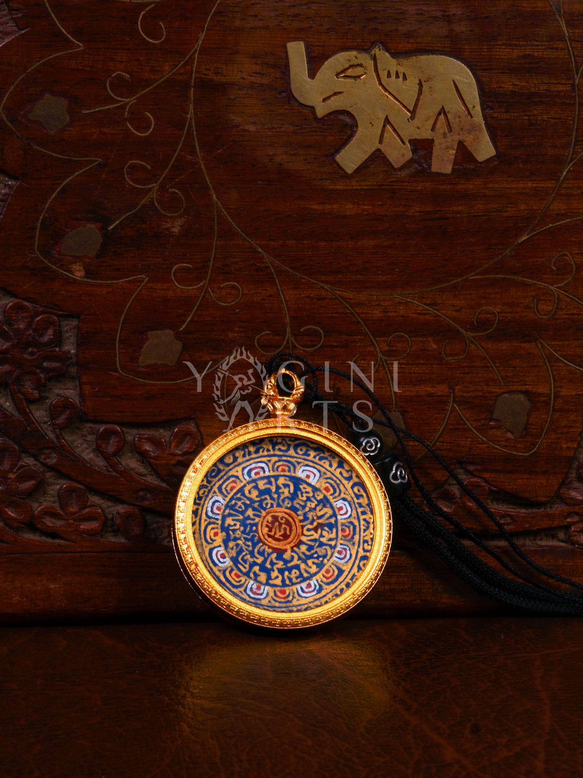 Hand-painted Mantra Mandala Ghau pendant featuring the sacred OM symbol and Tibetan Buddhist mantras in a handcrafted gold-tone frame.