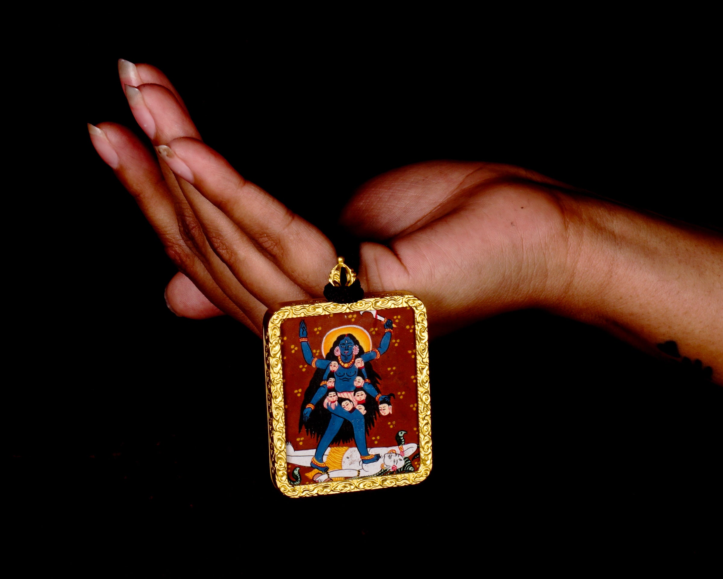 Hand-painted Goddess Kali miniature Thangka pendant in gold-accented copper Ghau locket with black beaded cord.