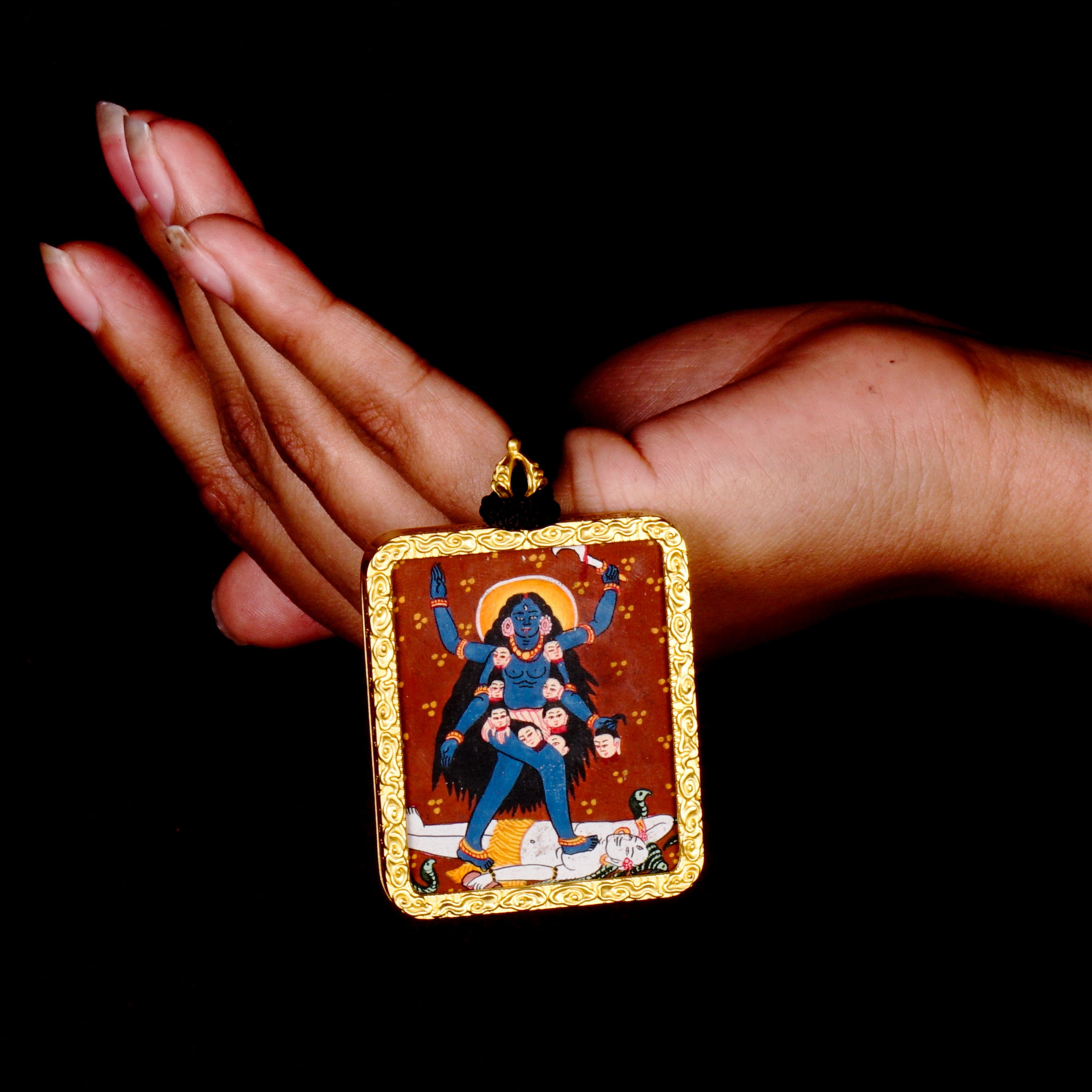 Hand-painted Goddess Kali miniature Thangka pendant in gold-accented copper Ghau locket with black beaded cord.