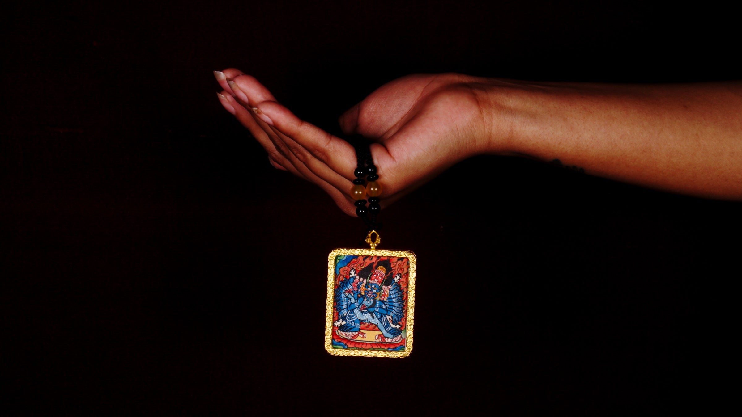 Hand-painted Yamantaka miniature Thangka pendant in gold-accented copper Ghau locket with black beaded cord.