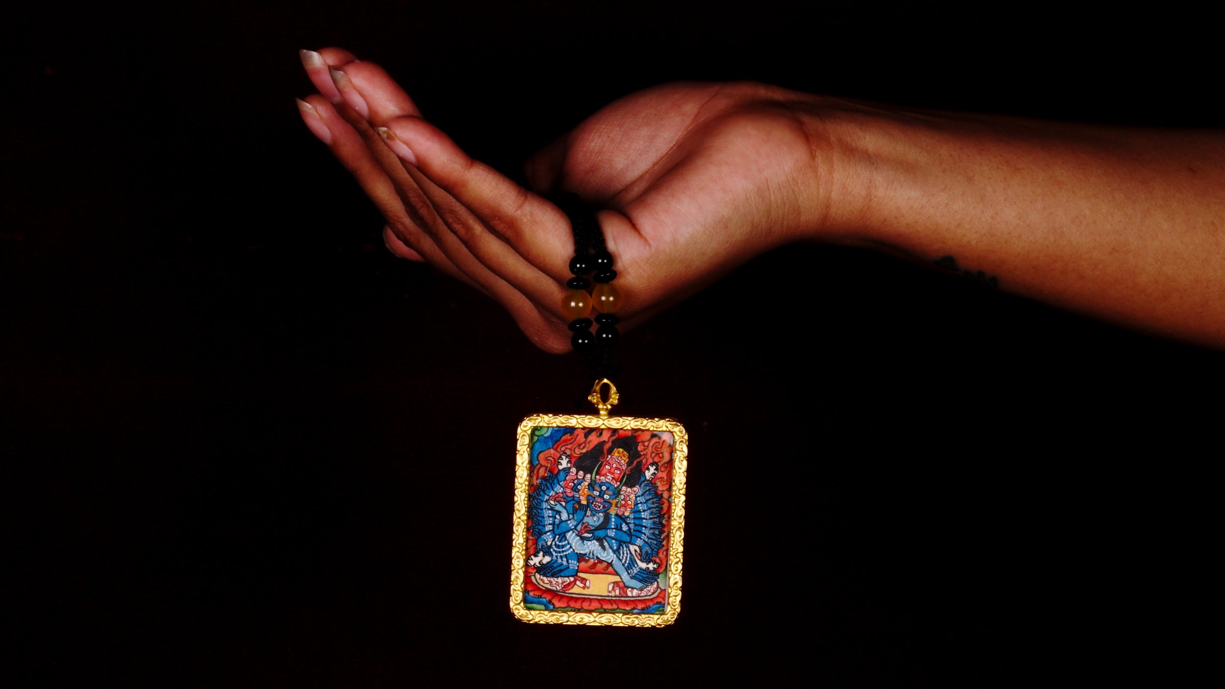 Hand-painted Yamantaka miniature Thangka pendant in gold-accented copper Ghau locket with black beaded cord.