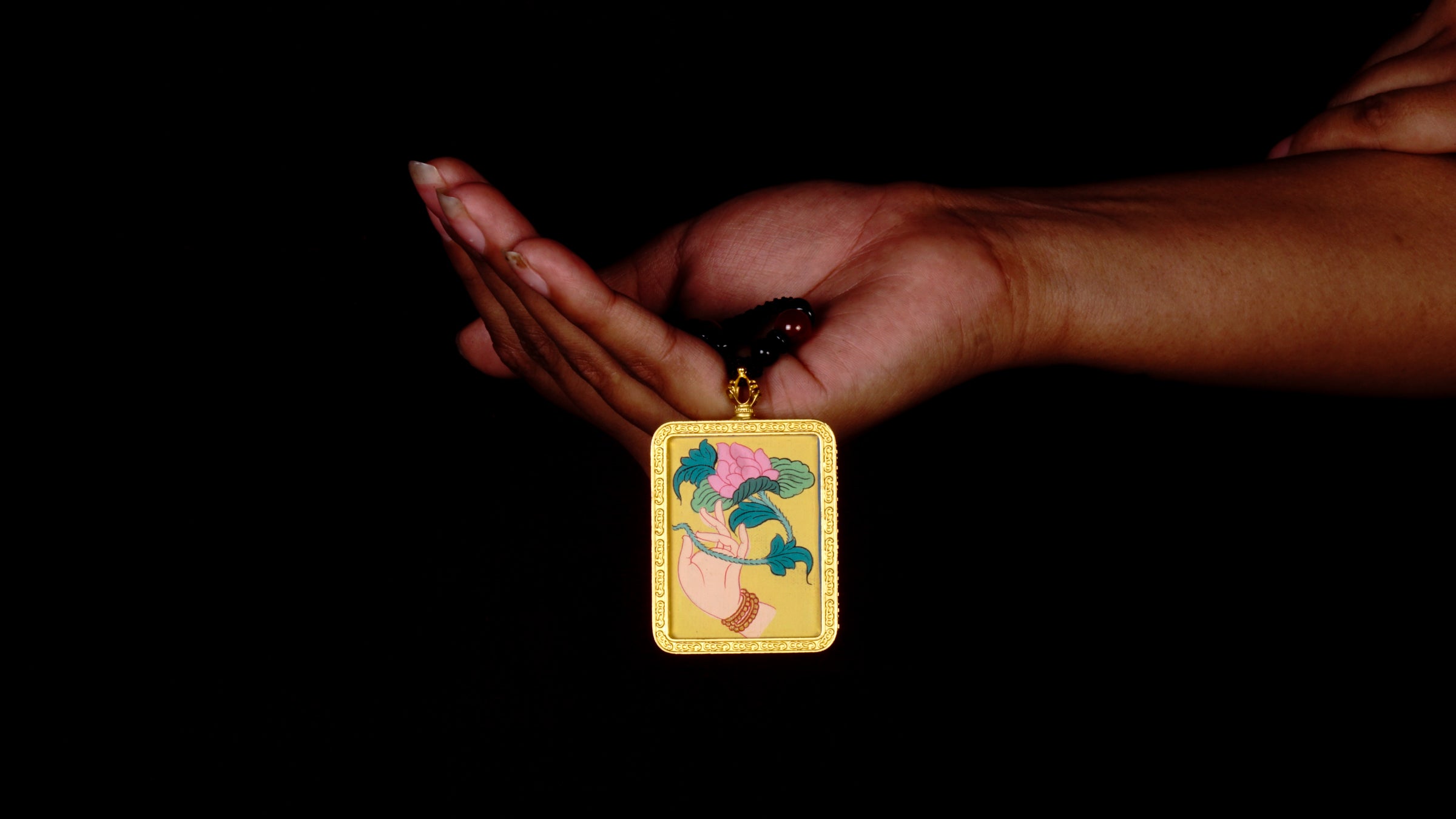 Hand-painted lotus flower in sacred hand miniature Thangka pendant inside gold-accented copper Ghau locket with black beaded cord.