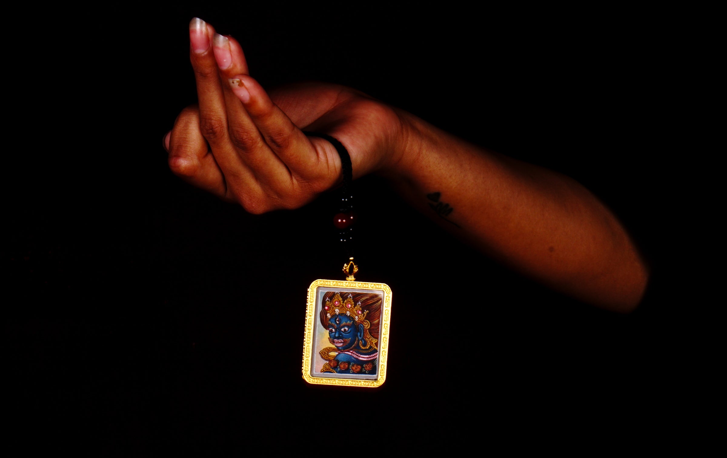Hand-painted Mahakala miniature Thangka pendant in gold-accented copper Ghau locket with black beaded cord.