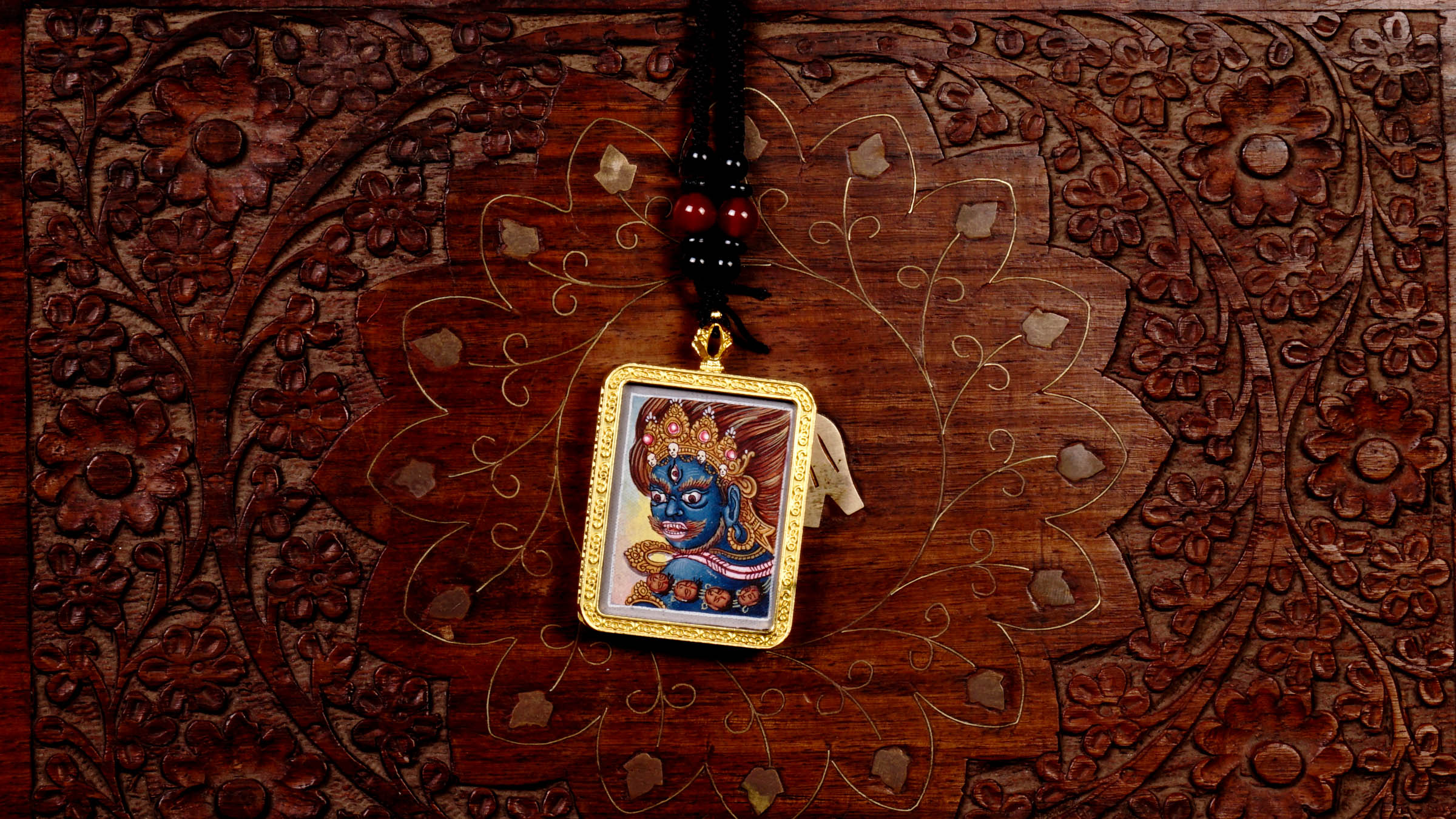 Hand-painted Mahakala miniature Thangka pendant in gold-accented copper Ghau locket with black beaded cord.