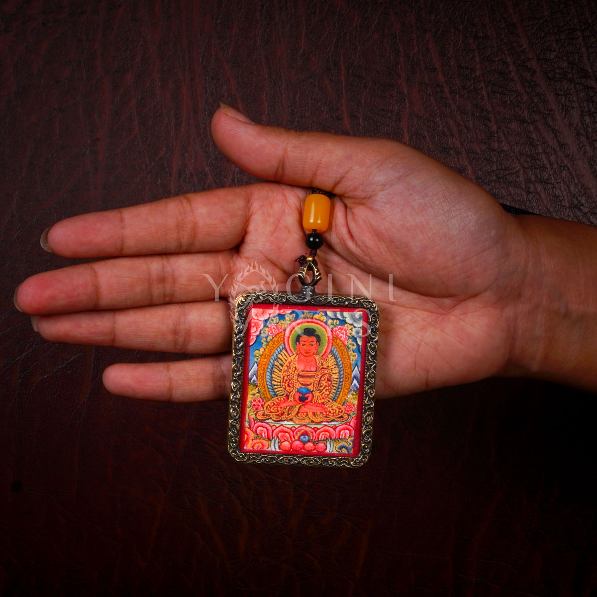 Hand-painted Amitabha Buddha Ghau pendant in an antique silver-tone frame, handcrafted in Nepal using traditional Himalayan miniature painting techniques.