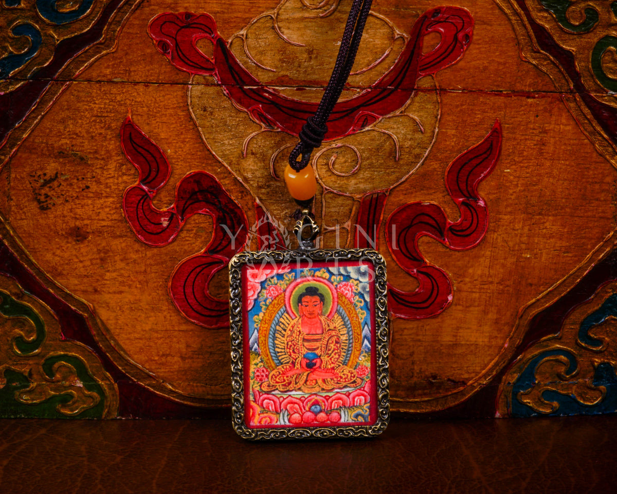 Hand-painted Amitabha Buddha Ghau pendant in an antique silver-tone frame, handcrafted in Nepal using traditional Himalayan miniature painting techniques.