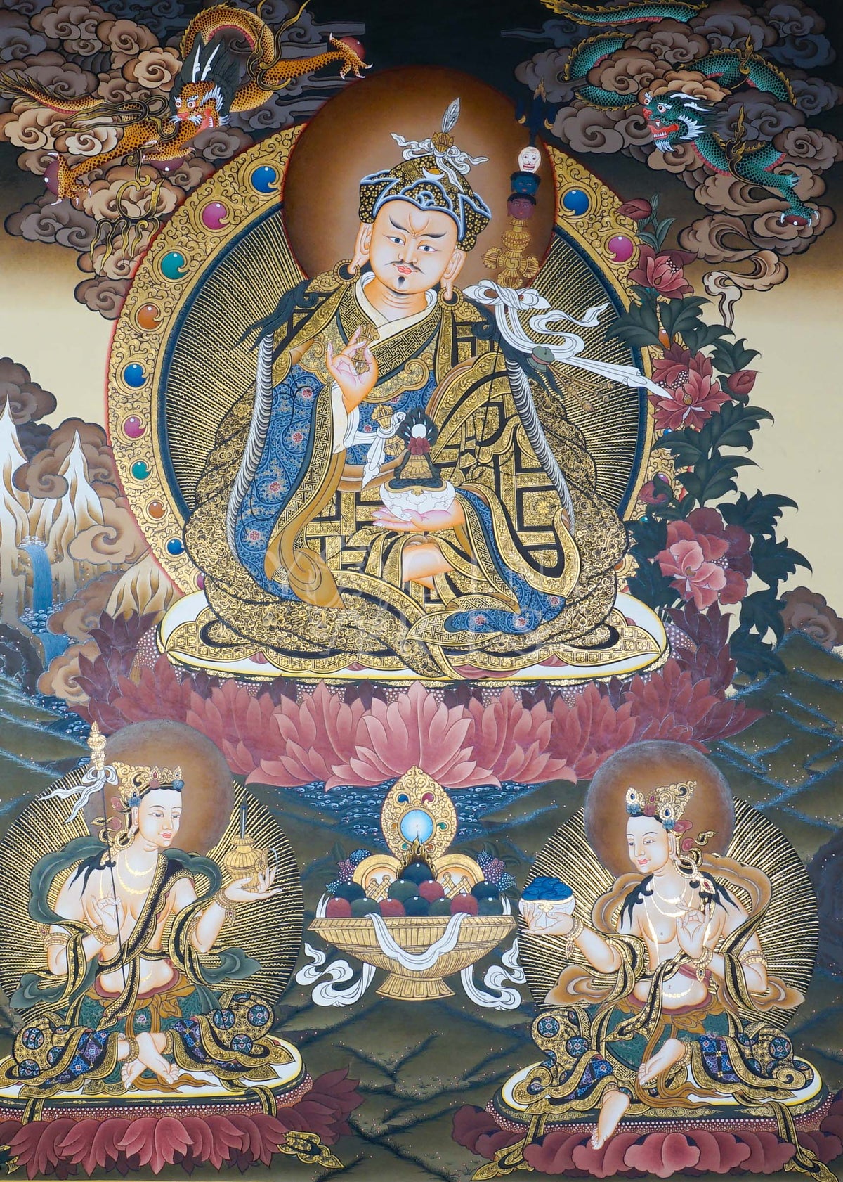 Hand-painted Guru Rinpoche Thangka featuring Guru Padmasambhava with White Tara and Amitayus, natural mineral pigments, gold detailing, and a traditional Himalayan landscape.