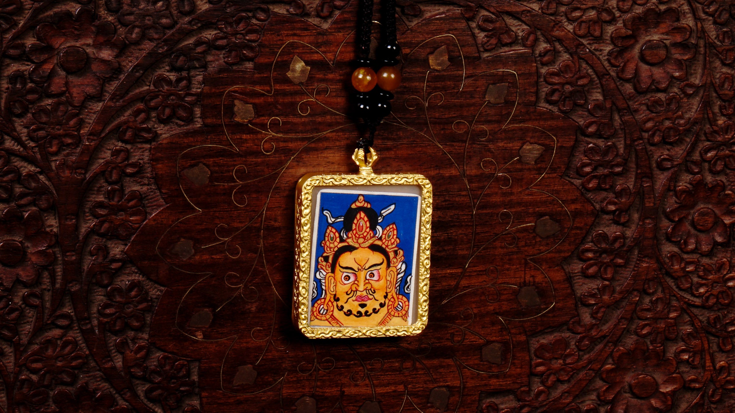 Hand-painted Zambala wealth deity miniature Thangka pendant in gold-accented copper Ghau locket with black beaded cord.