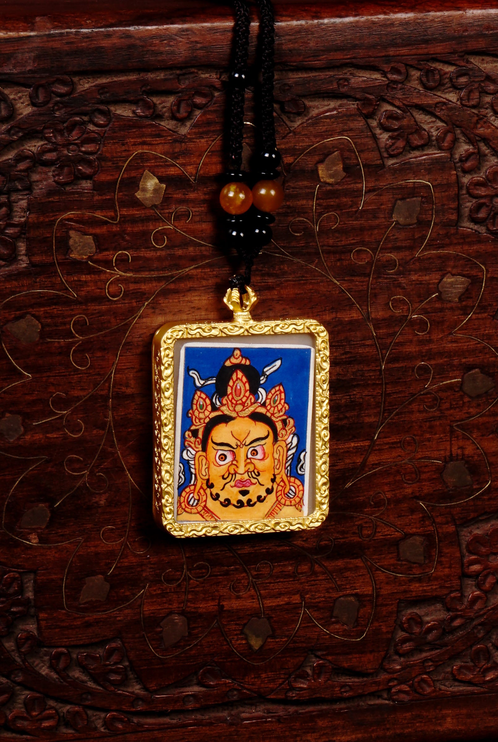 Hand-painted Zambala wealth deity miniature Thangka pendant in gold-accented copper Ghau locket with black beaded cord.