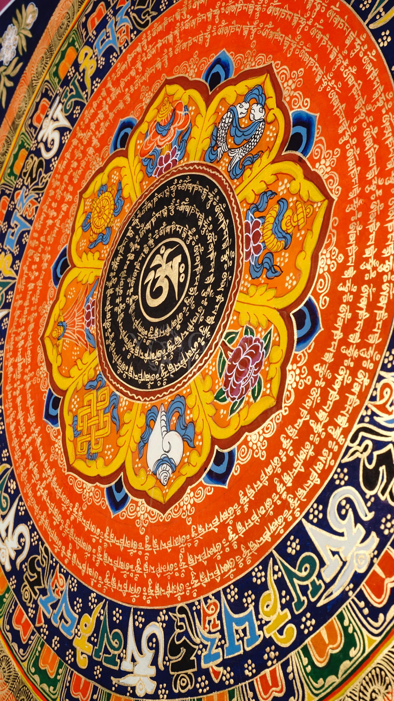 Hand-painted Tibetan Sacred Om Lotus Mantra Mandala thangka featuring central Om symbol, concentric Tibetan mantra circles, lotus petals, and vibrant Buddhist sacred geometry.