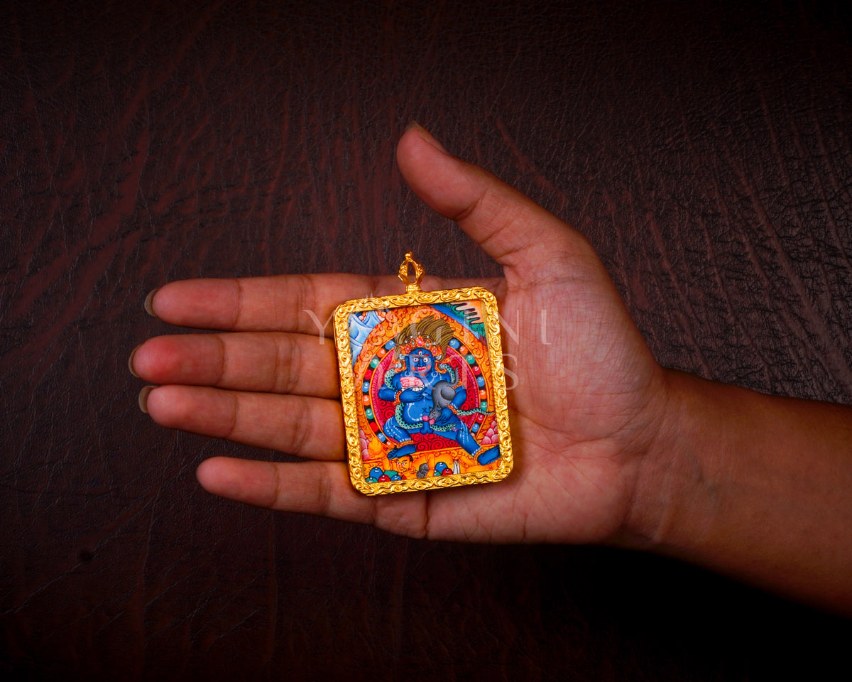 Hand-painted Black Zambhala Ghau pendant in a gold-tone frame, handcrafted in Nepal using traditional Tibetan miniature painting techniques.