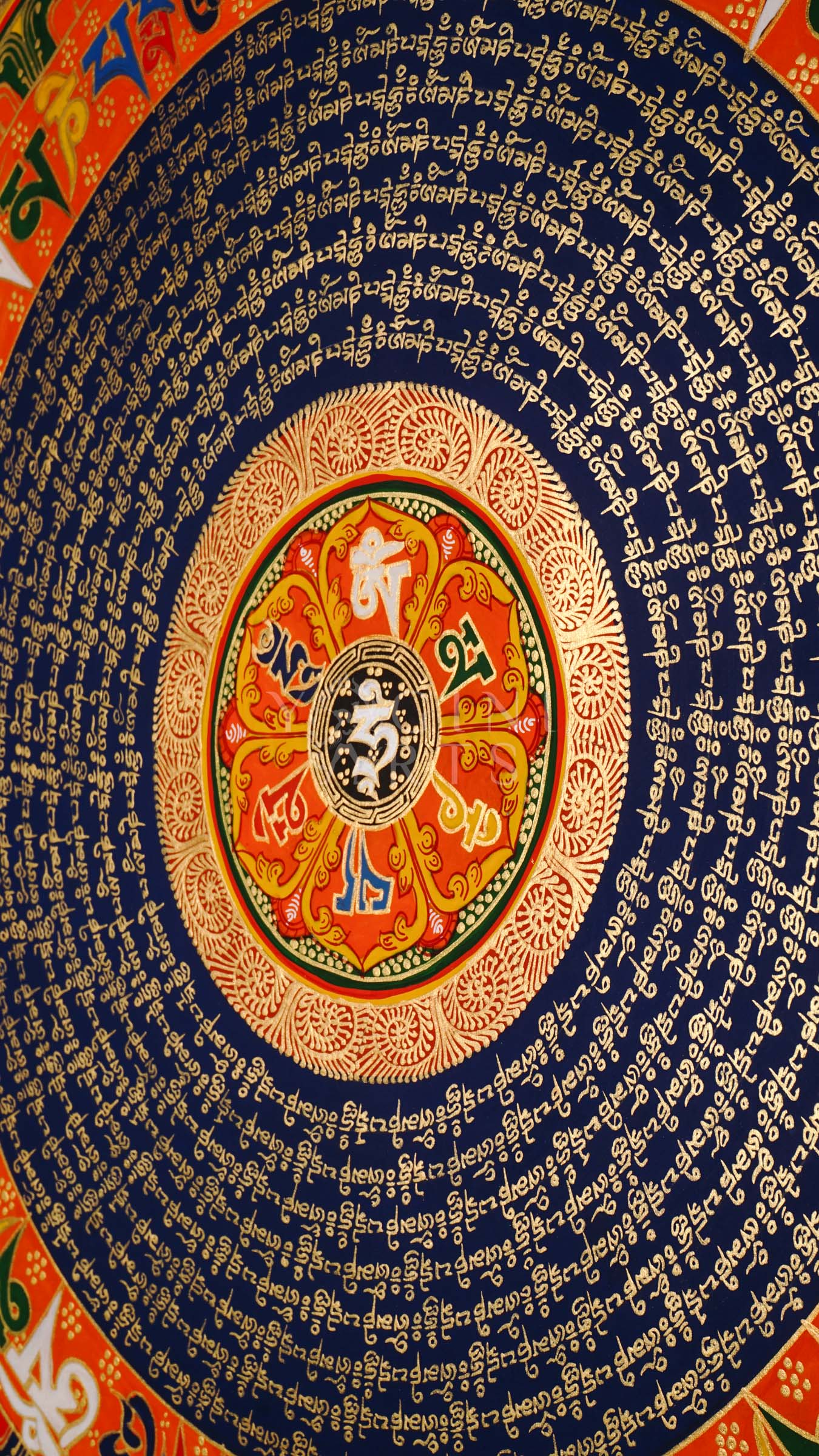 Tibetan mantra mandala thangka with blue background, gold script rings, colorful outer mantra band, and floral corner decorations.