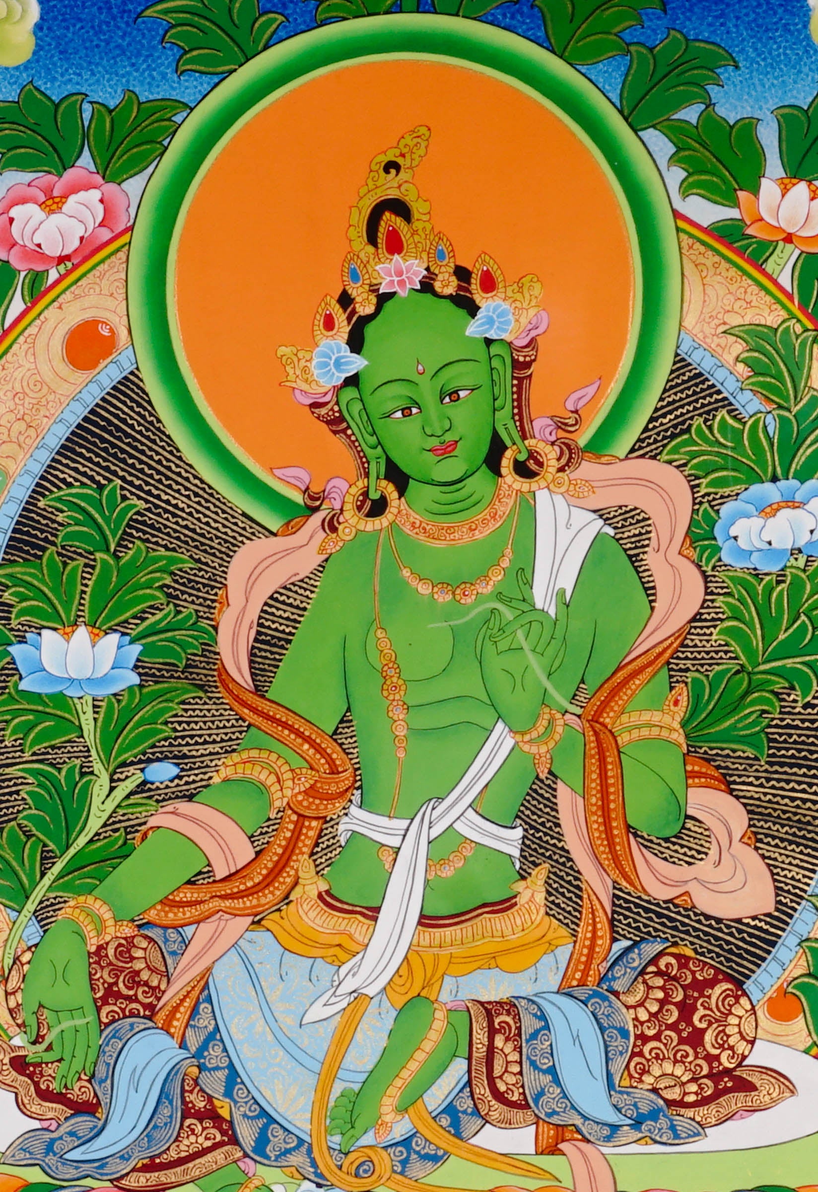 Green Tara thangka featuring the Tibetan Buddhist goddess seated on a lotus throne surrounded by flowers and sacred Himalayan landscape