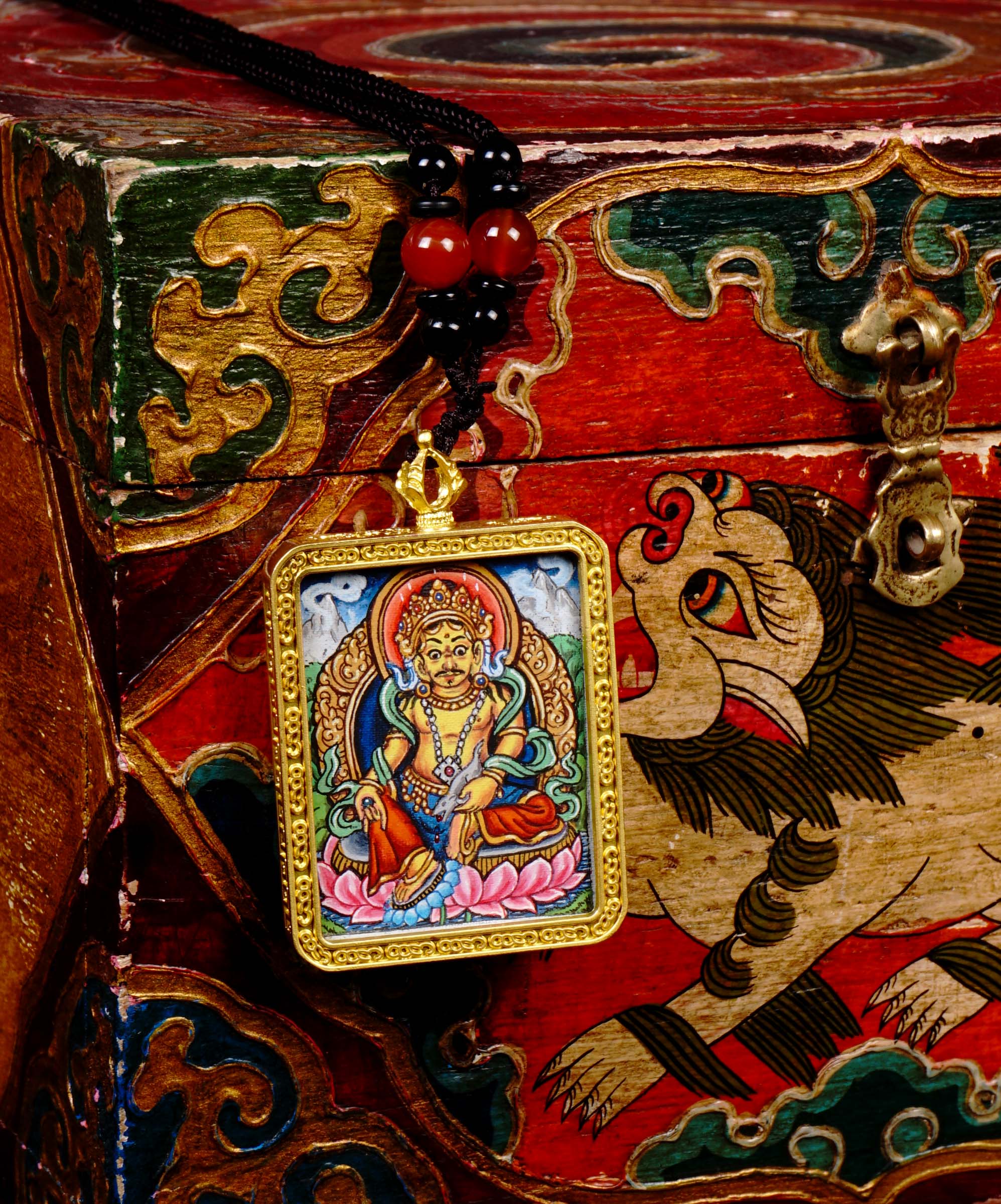 Hand-painted Zambala miniature Thangka pendant inside gold-accented copper Ghau locket with black and red beaded cord.