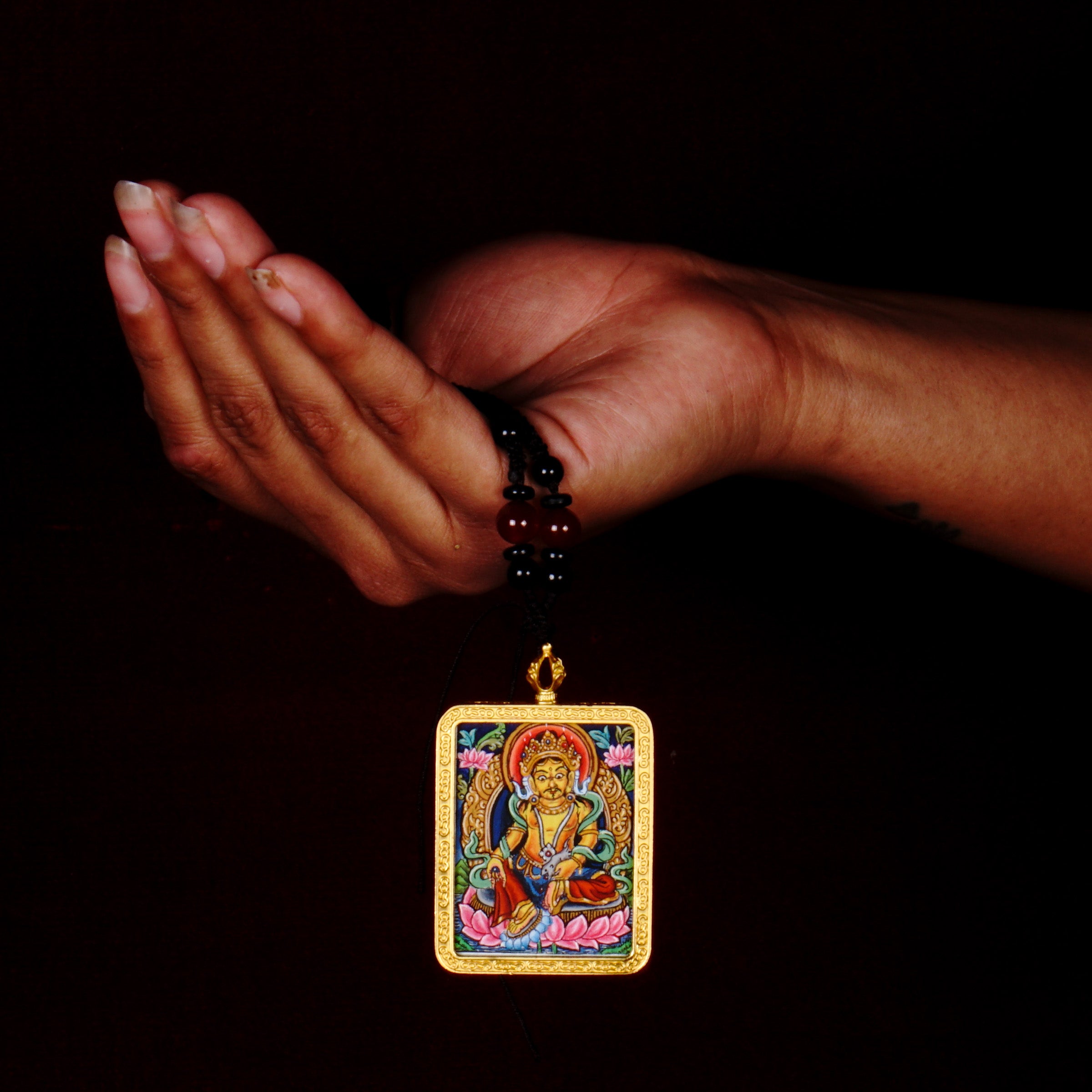 Hand-painted Yellow Zambala miniature Thangka pendant in gold-accented copper Ghau locket with black beaded cord.