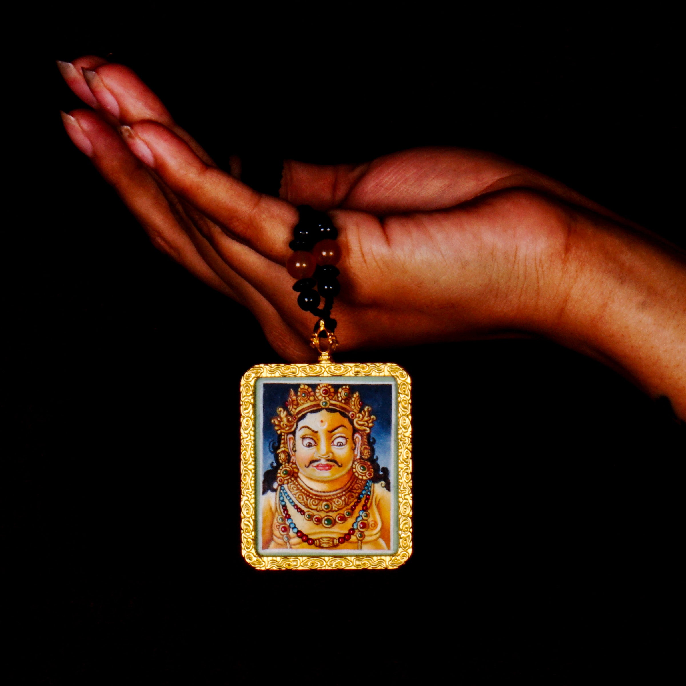 Hand-painted Zambala portrait miniature Thangka pendant in gold-accented copper Ghau locket with black beaded cord.