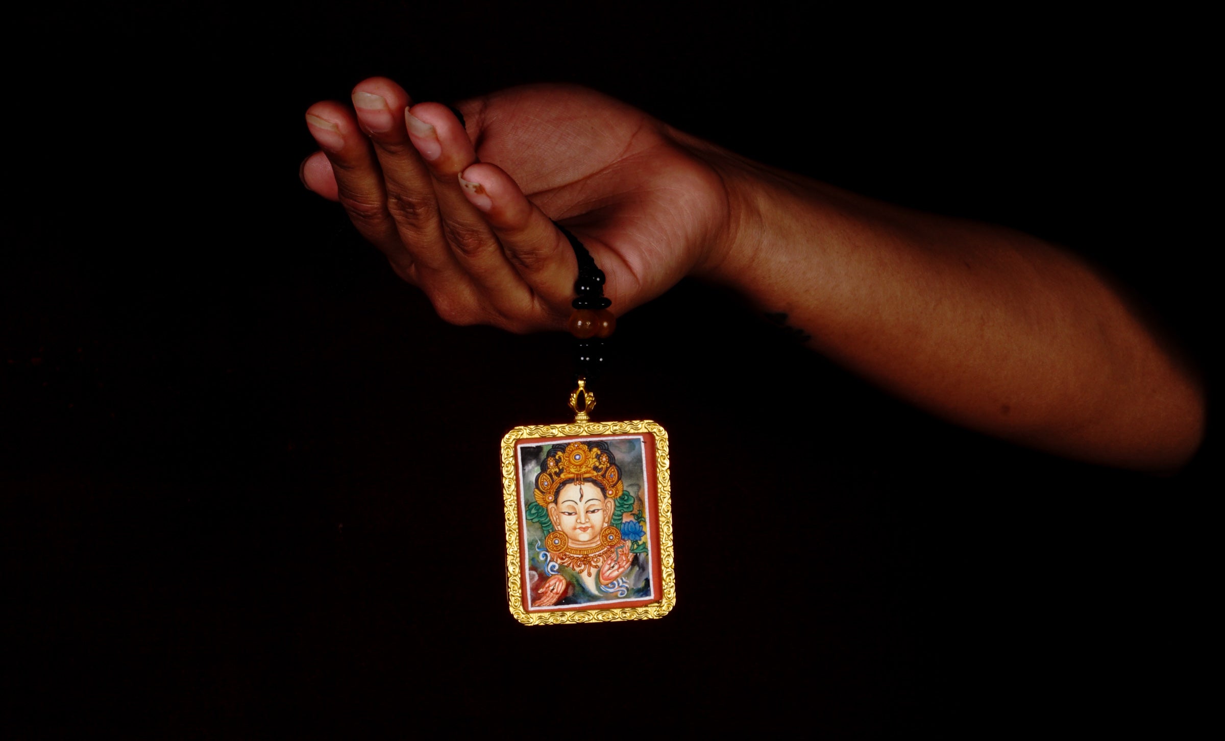 Hand-painted White Tara miniature Thangka pendant in gold-accented copper Ghau locket with black beaded cord.